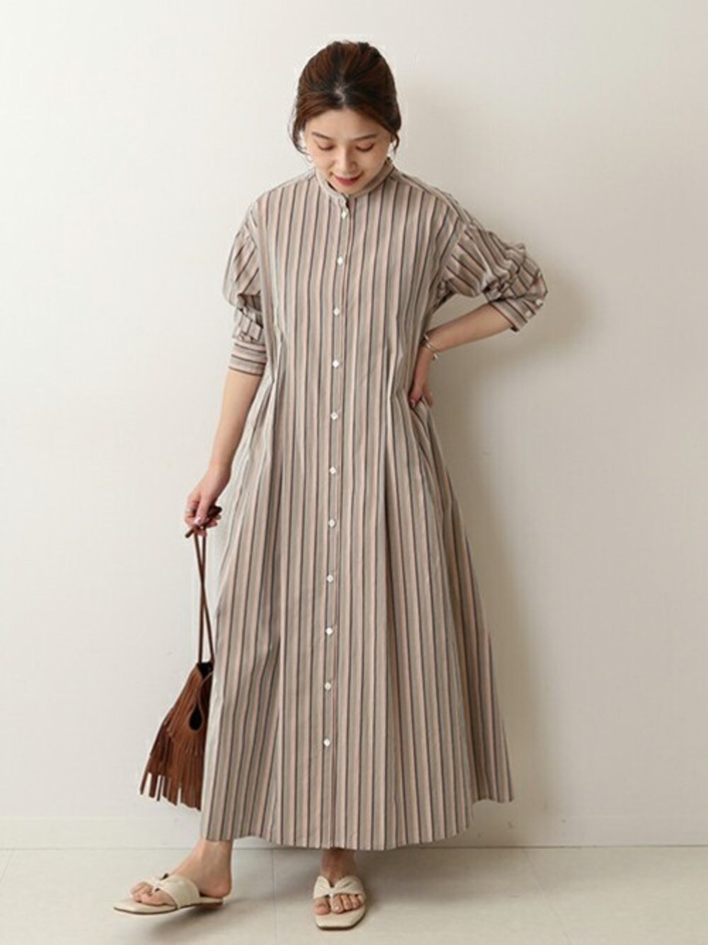 グリーン系のワンピース、ブラウン系のショルダーバッグ、ベージュ系のサンダルを着用したレディースの春コーディネートの1枚目の写真