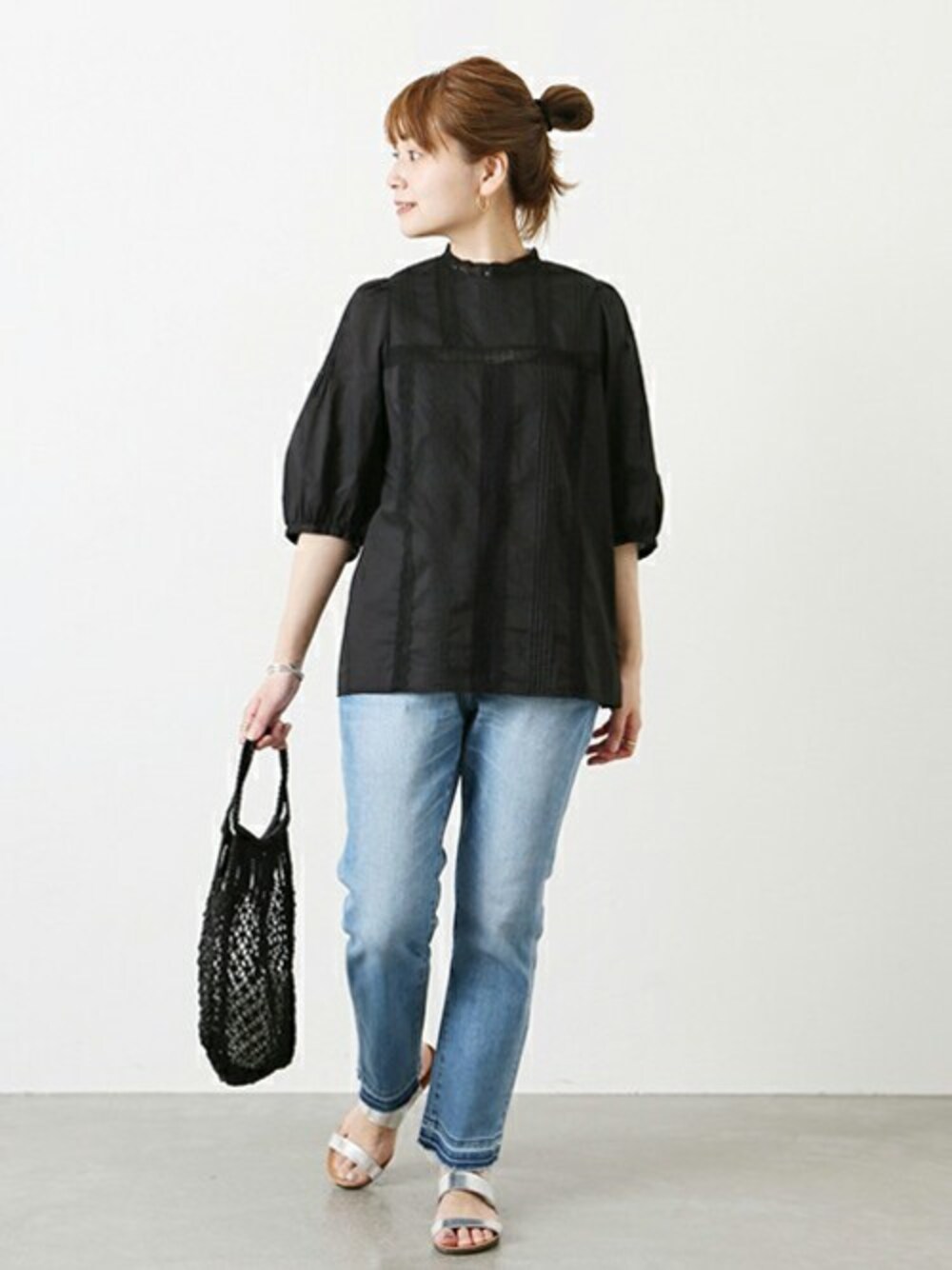 ブラック系のシャツ/ブラウス、ブルー系のデニムパンツ、ブラック系のトートバッグを着用したレディースの春コーディネートの1枚目の写真