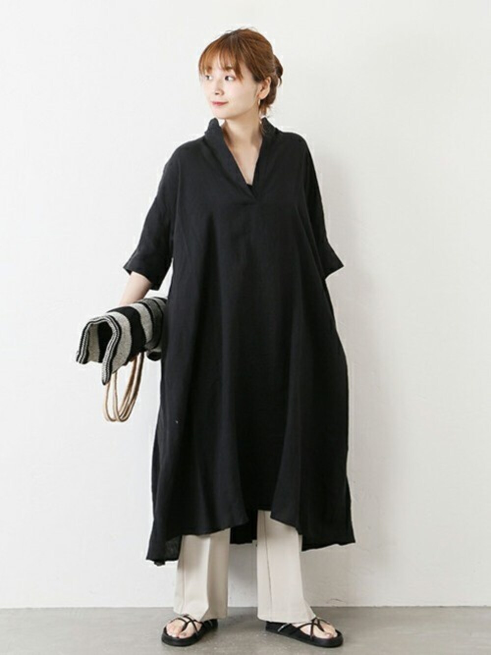 ブラック系のワンピース、ホワイト系のトートバッグ、ブラック系のサンダルを着用したレディースの春コーディネートの1枚目の写真