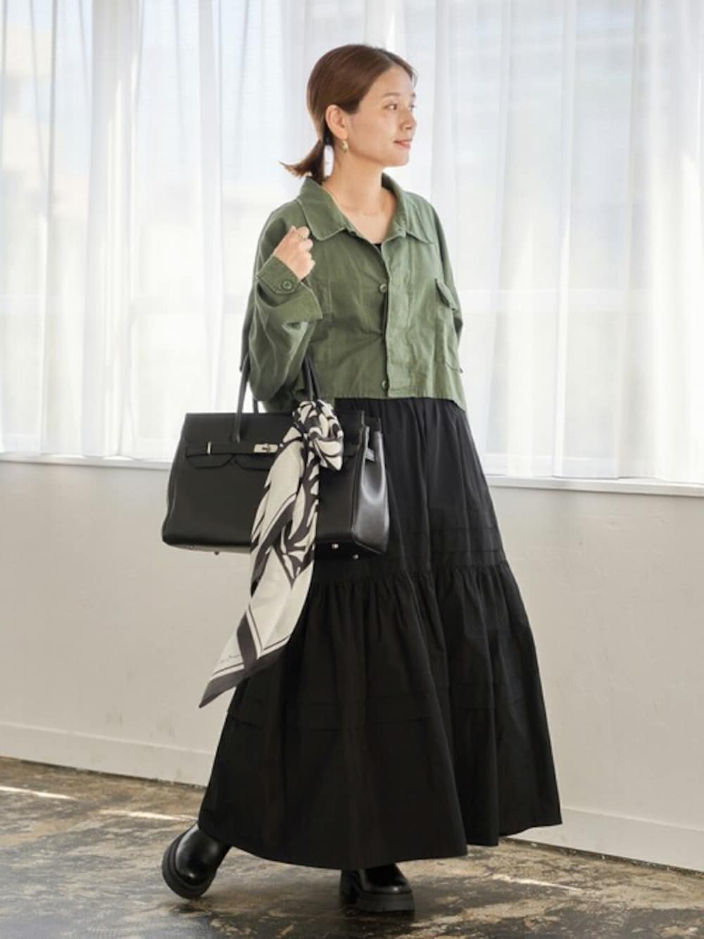 ブラック系のスカート、ブラック系のブーツ、ブラック系のトートバッグを着用したレディースの秋コーディネートの1枚目の写真