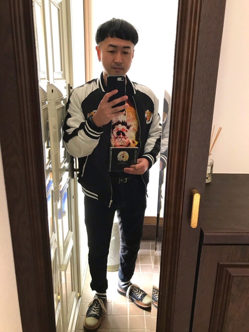 ブラック系のスカジャン、ブラック系のTシャツ/カットソー、ブラック系のパンツを着用したメンズの冬コーディネートの1枚目の写真