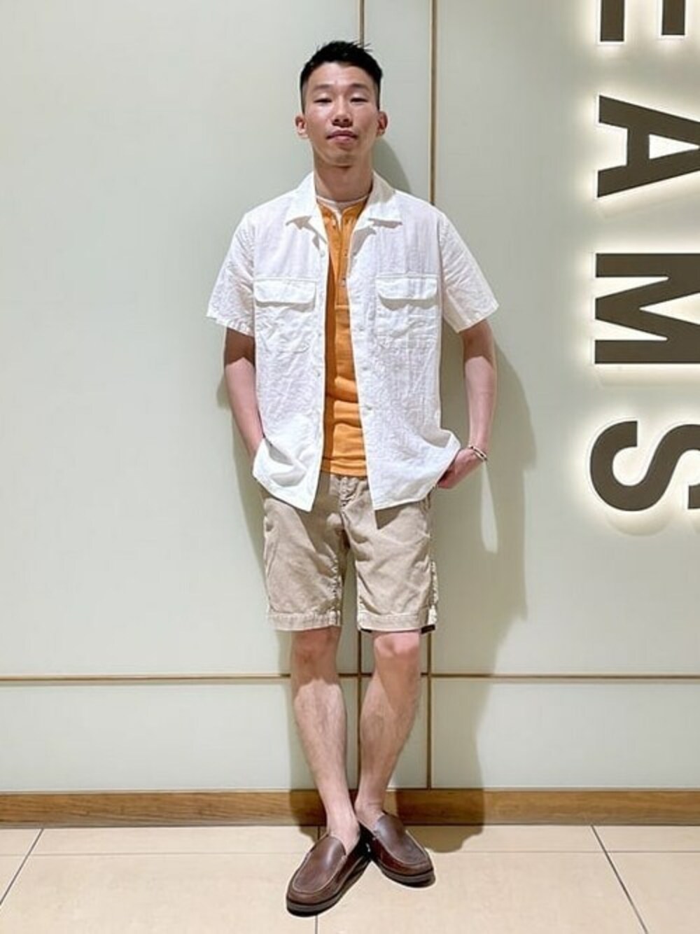 オレンジ系のTシャツ/カットソー、ホワイト系のシャツ/ブラウス、ベージュ系のその他パンツを着用したメンズの夏コーディネートの1枚目の写真