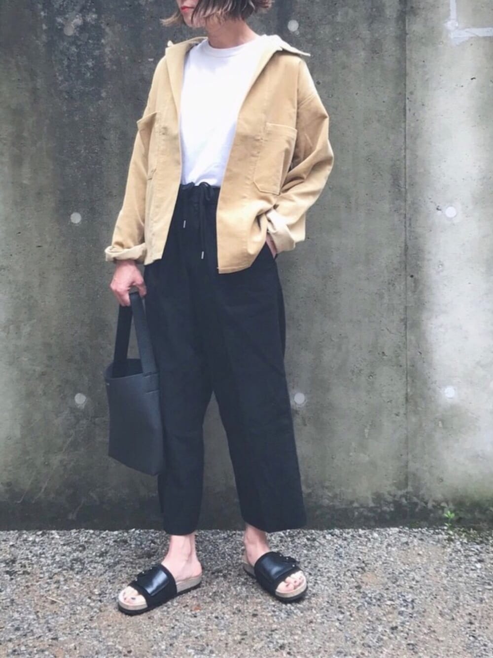 イエロー系のその他アウター、ホワイト系のTシャツ/カットソー、ブラック系のスラックスを着用したレディースの春コーディネートの1枚目の写真