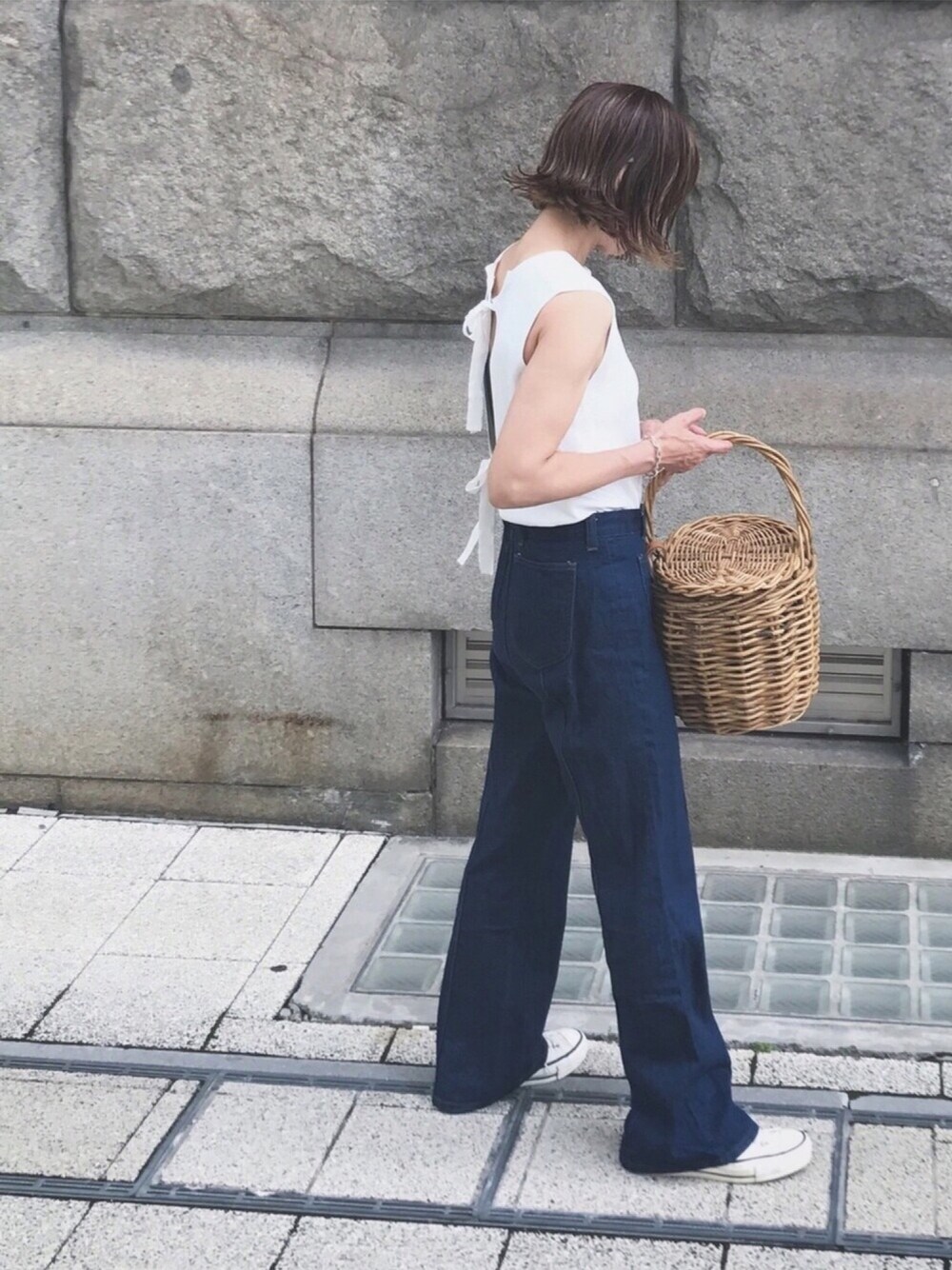 ブラウン系のTシャツ/カットソー、ホワイト系のニット/セーター、ブラウン系のかごバッグを着用したレディースの夏コーディネートの1枚目の写真