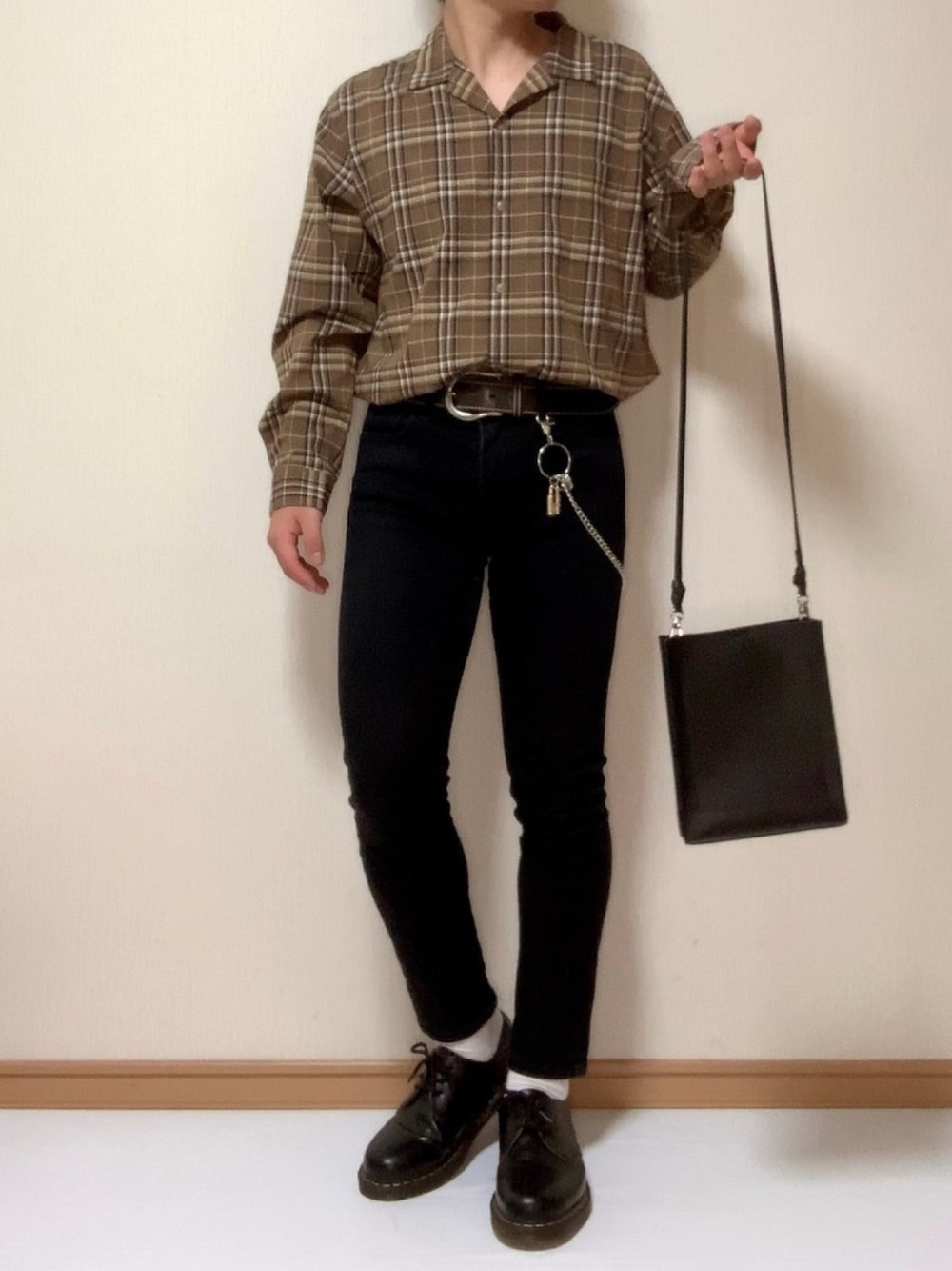 ブラック系のショルダーバッグ、ブラック系のドレスシューズ、ブラウン系のシャツ/ブラウスを着用したメンズの秋コーディネートの1枚目の写真