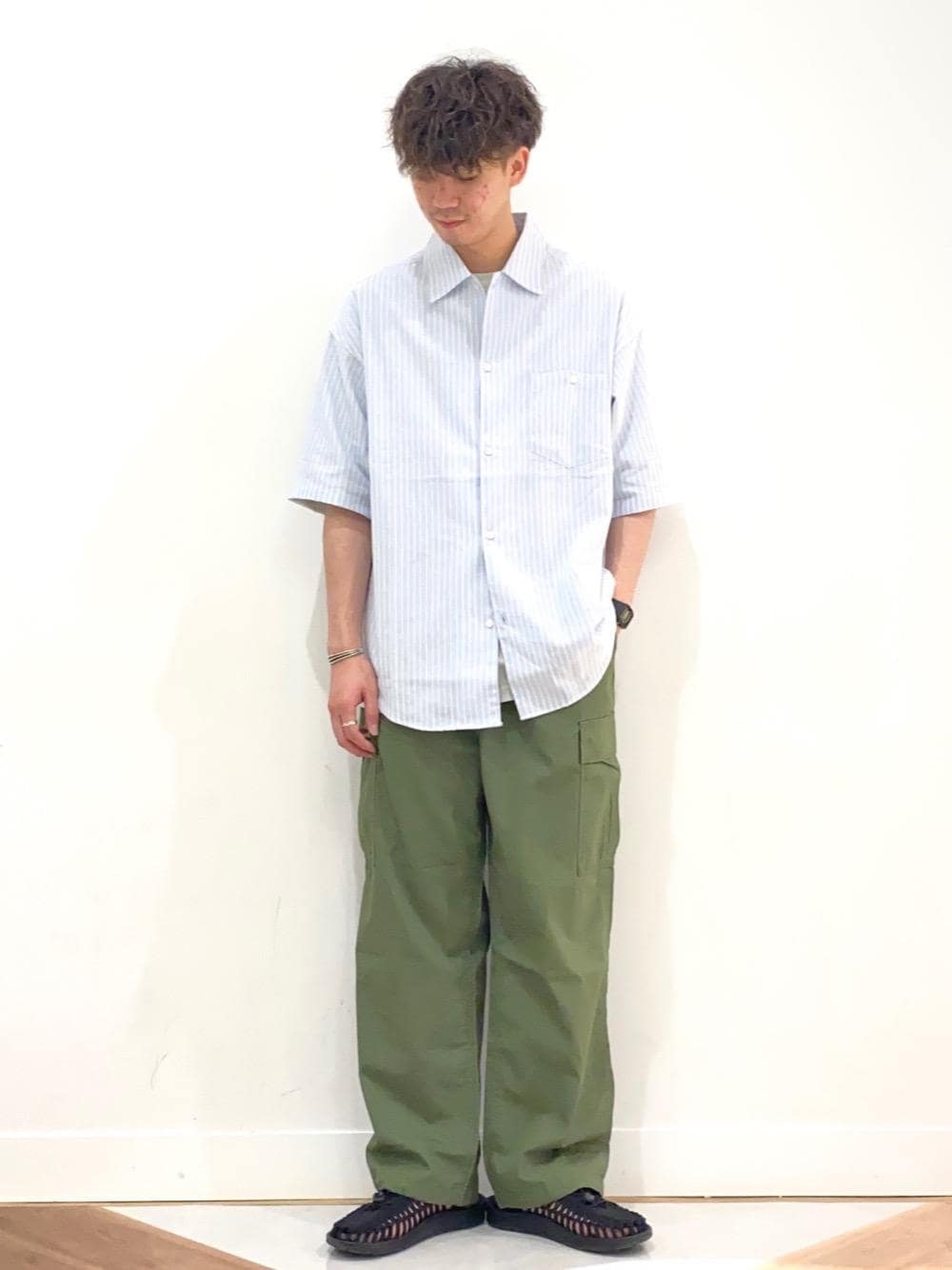 ブルー系のシャツ/ブラウス、グリーン系のカーゴパンツを着用したメンズの夏コーディネートの1枚目の写真