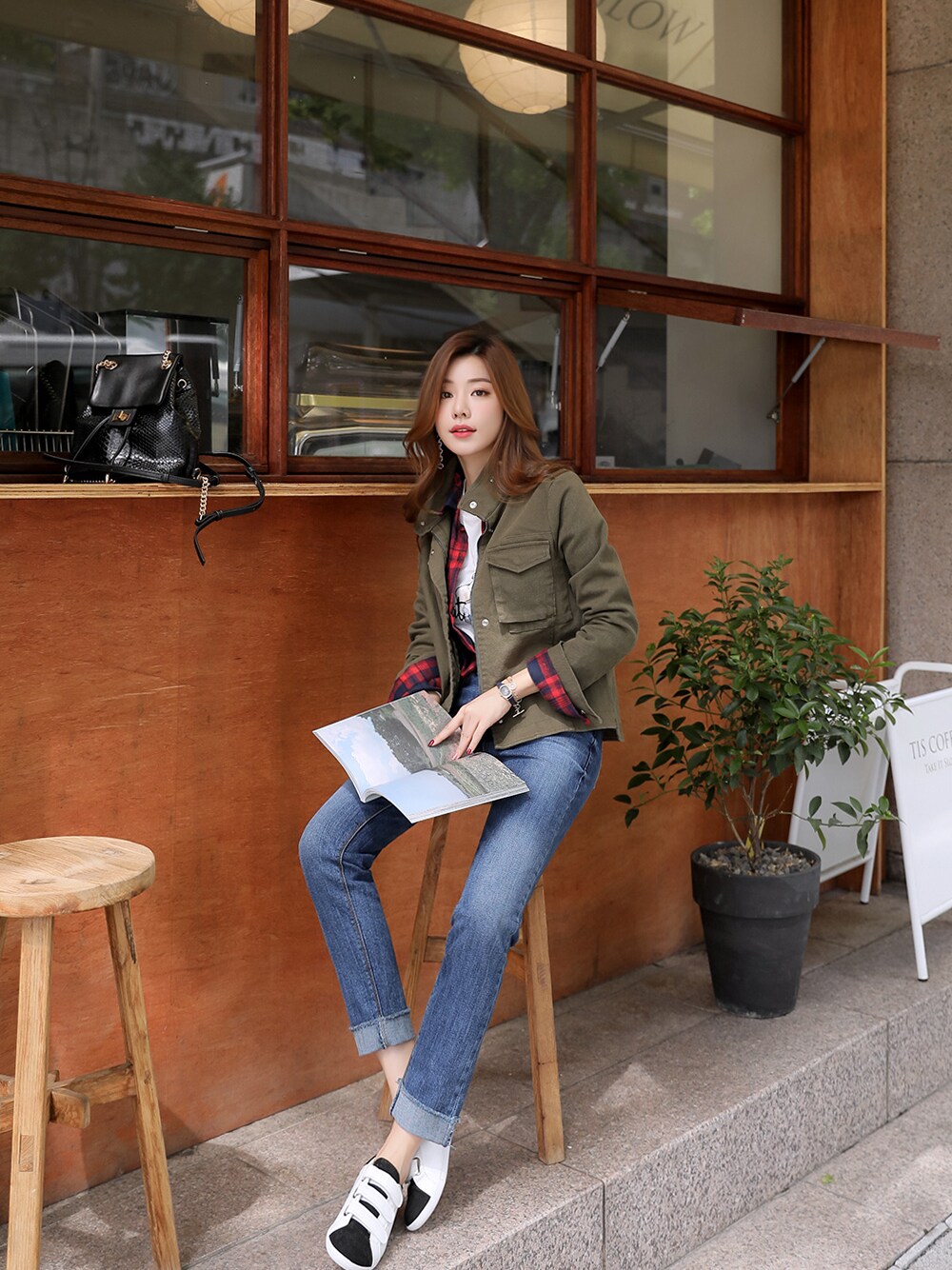 ホワイト系のTシャツ/カットソー、レッド系のシャツ/ブラウス、グリーン系のミリタリージャケットを着用したレディースの秋コーディネートの1枚目の写真