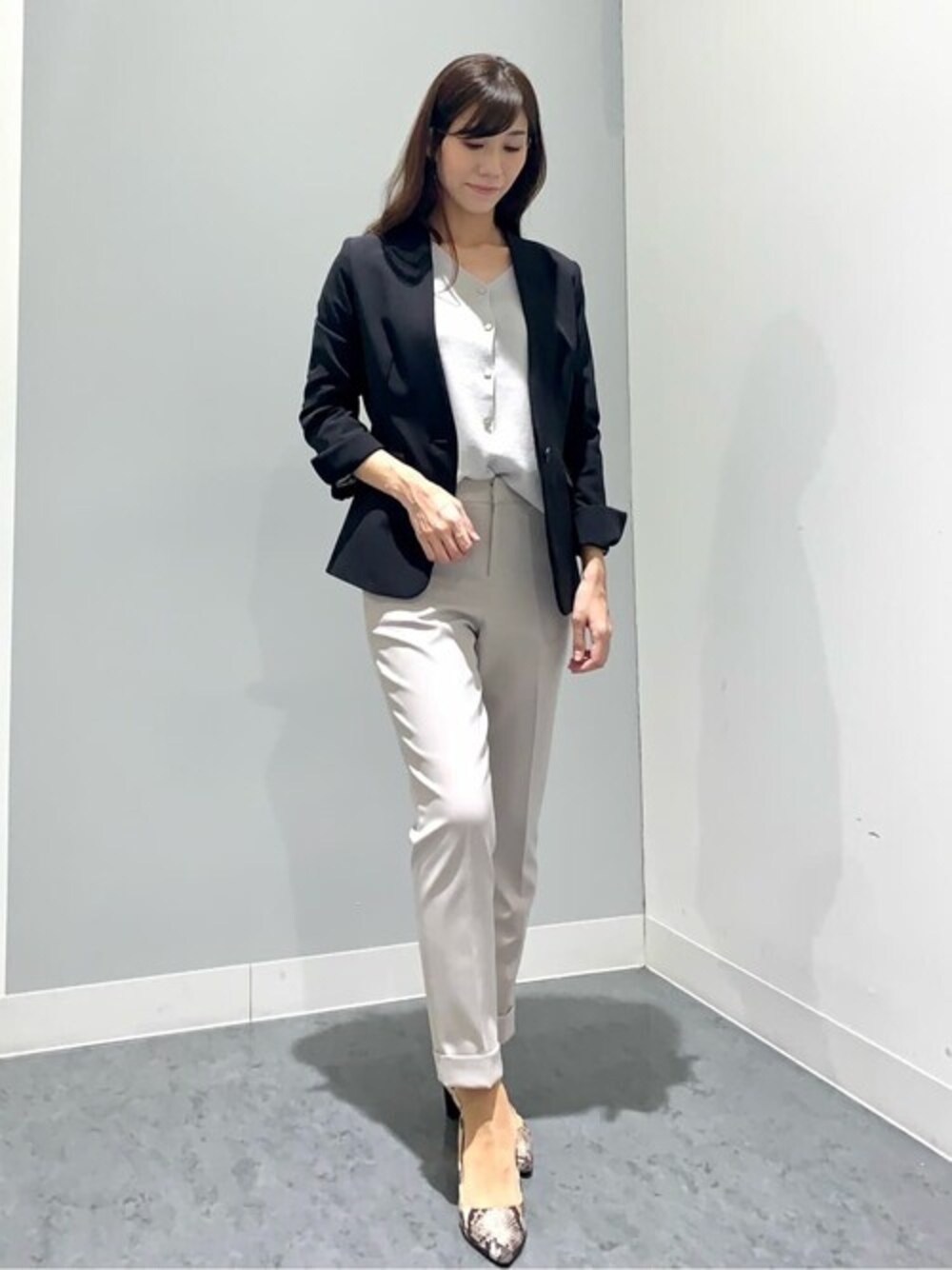 ブラック系のスーツジャケット、グレー系のスーツパンツを着用したレディースの秋コーディネートの1枚目の写真