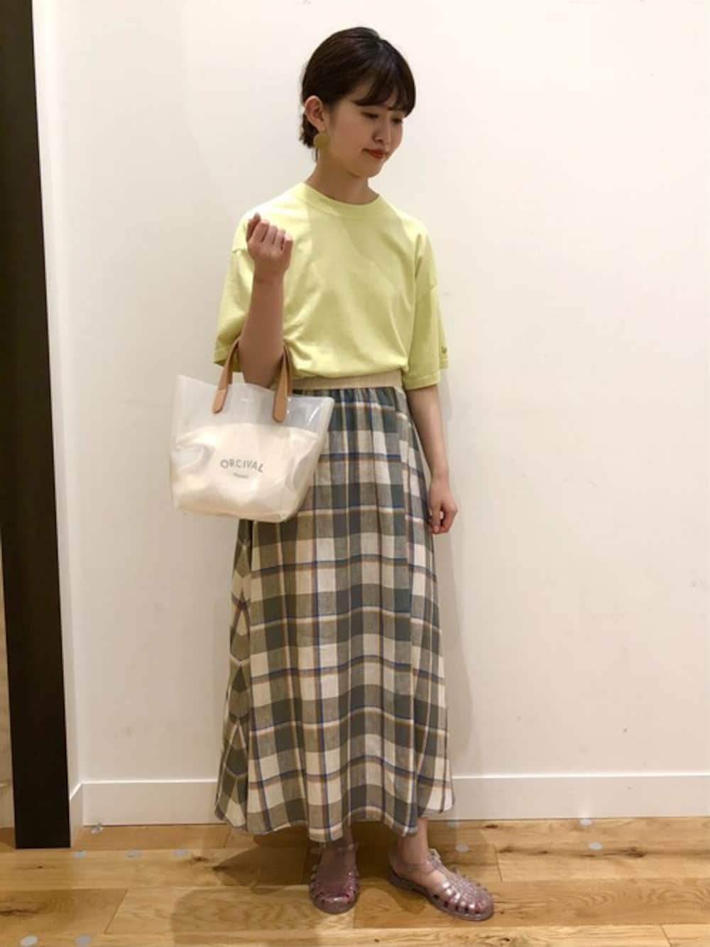 グリーン系のTシャツ/カットソー、グレー系のスカート、ホワイト系のトートバッグを着用したレディースの春コーディネートの1枚目の写真