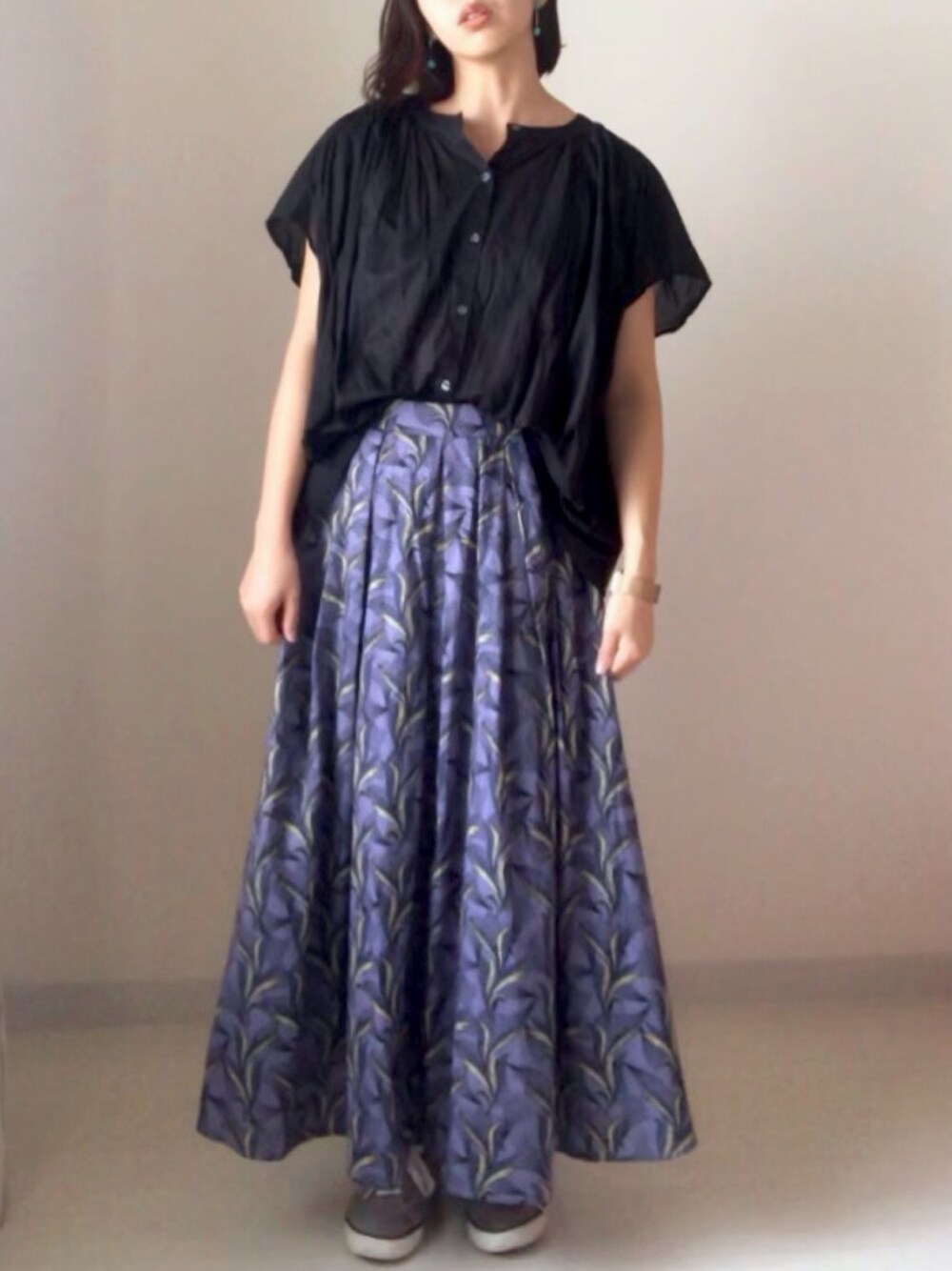 ブラック系のシャツ/ブラウス、パープル系のスカート、ベージュ系のスニーカーを着用したレディースの夏コーディネートの1枚目の写真