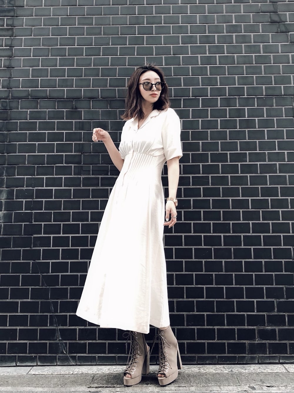 ホワイト系のワンピース、ベージュ系のブーツを着用したレディースの冬コーディネートの1枚目の写真