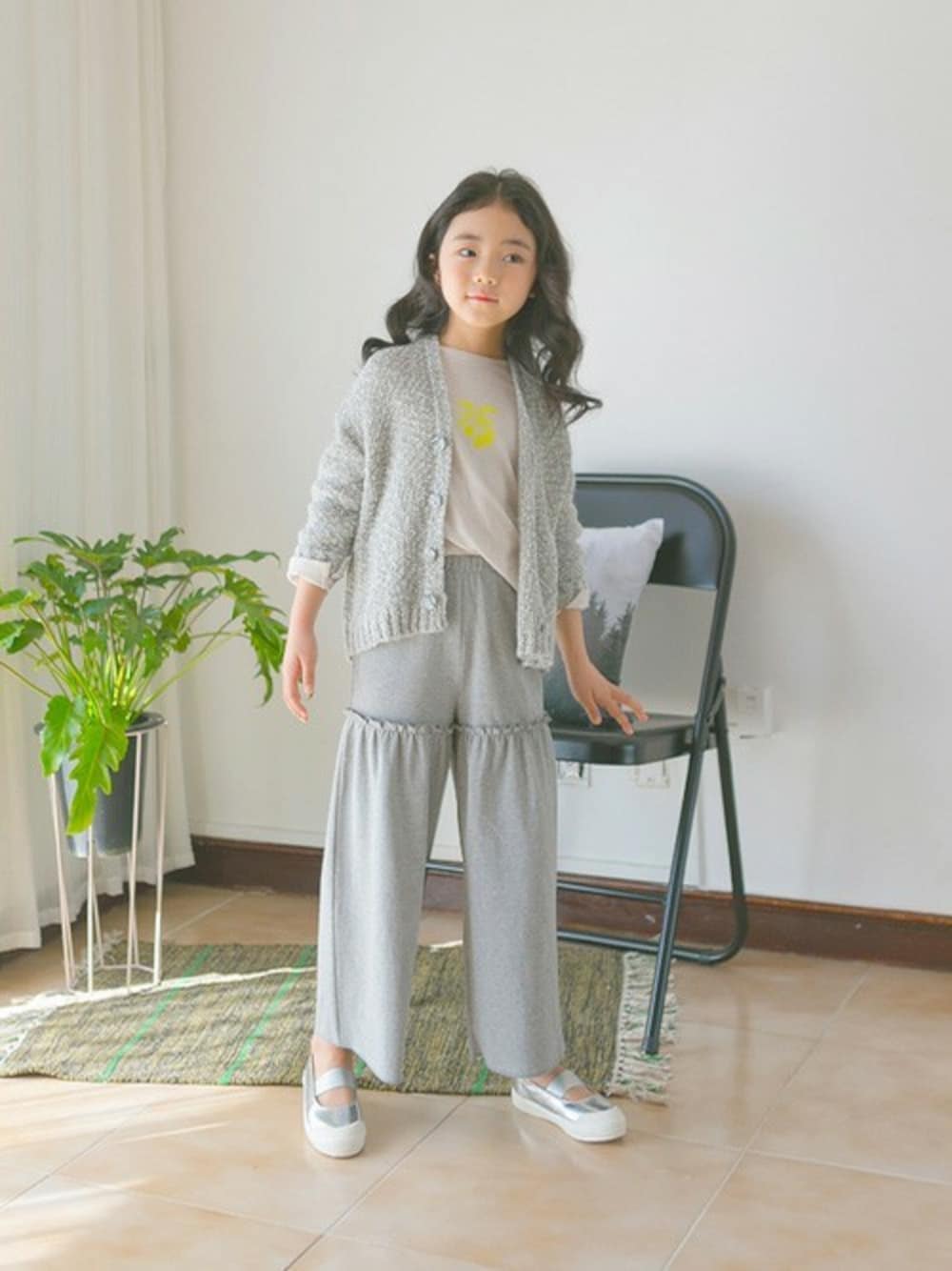 グレー系のその他パンツ、シルバー系のスニーカー、グレー系のカーディガン/ボレロを着用したキッズの春コーディネートの1枚目の写真