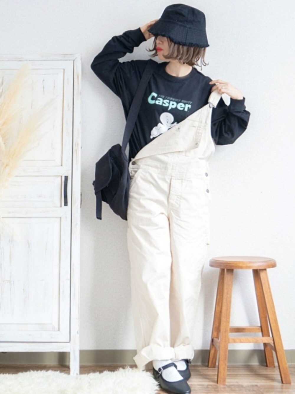 ホワイト系のサロペット/オーバーオール、ブラック系のTシャツ/カットソー、ブラック系のメッセンジャーバッグを着用したレディースの春コーディネートの1枚目の写真