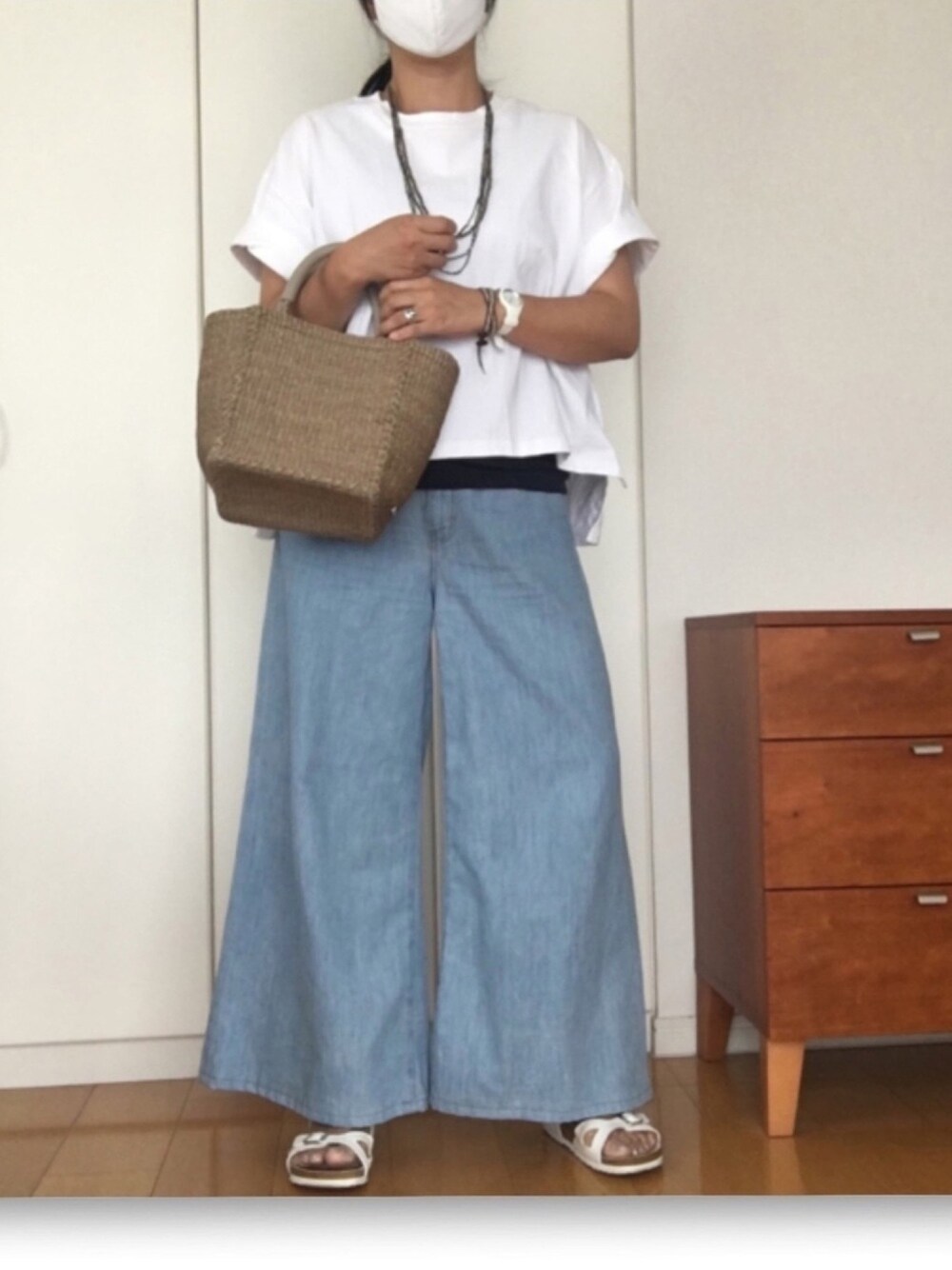 ホワイト系のTシャツ/カットソー、ブルー系のデニムパンツ、グレー系のかごバッグを着用したレディースの夏コーディネートの1枚目の写真