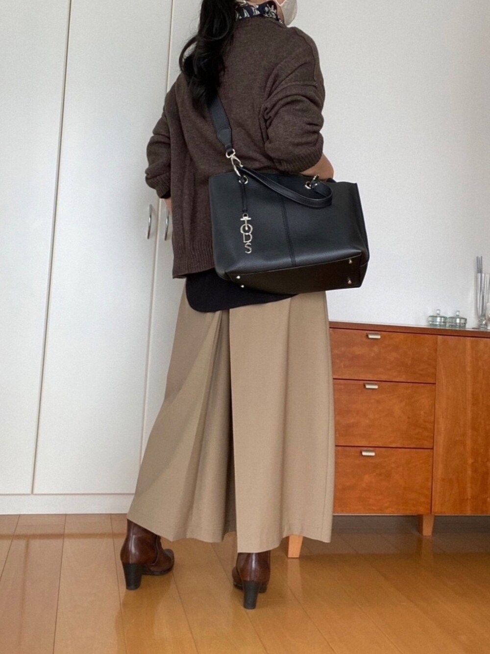 ブラウン系のニット/セーター、ベージュ系のその他パンツ、ブラック系のTシャツ/カットソーを着用したレディースの秋コーディネートの1枚目の写真