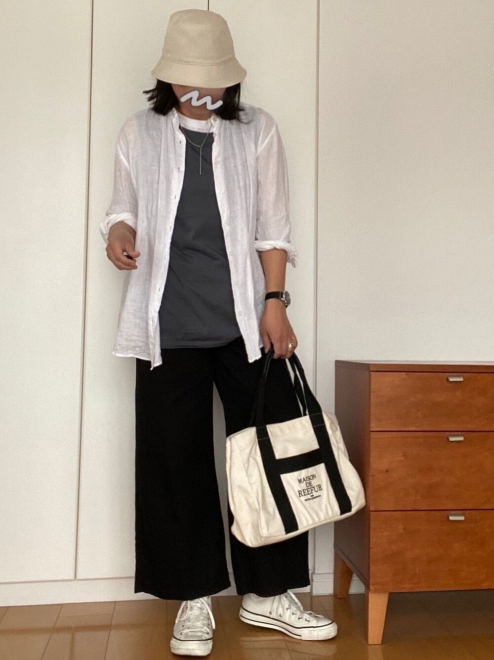 ブラック系のパンツ、ブラック系のトートバッグ、ホワイト系のスニーカーを着用したレディースの春コーディネートの1枚目の写真