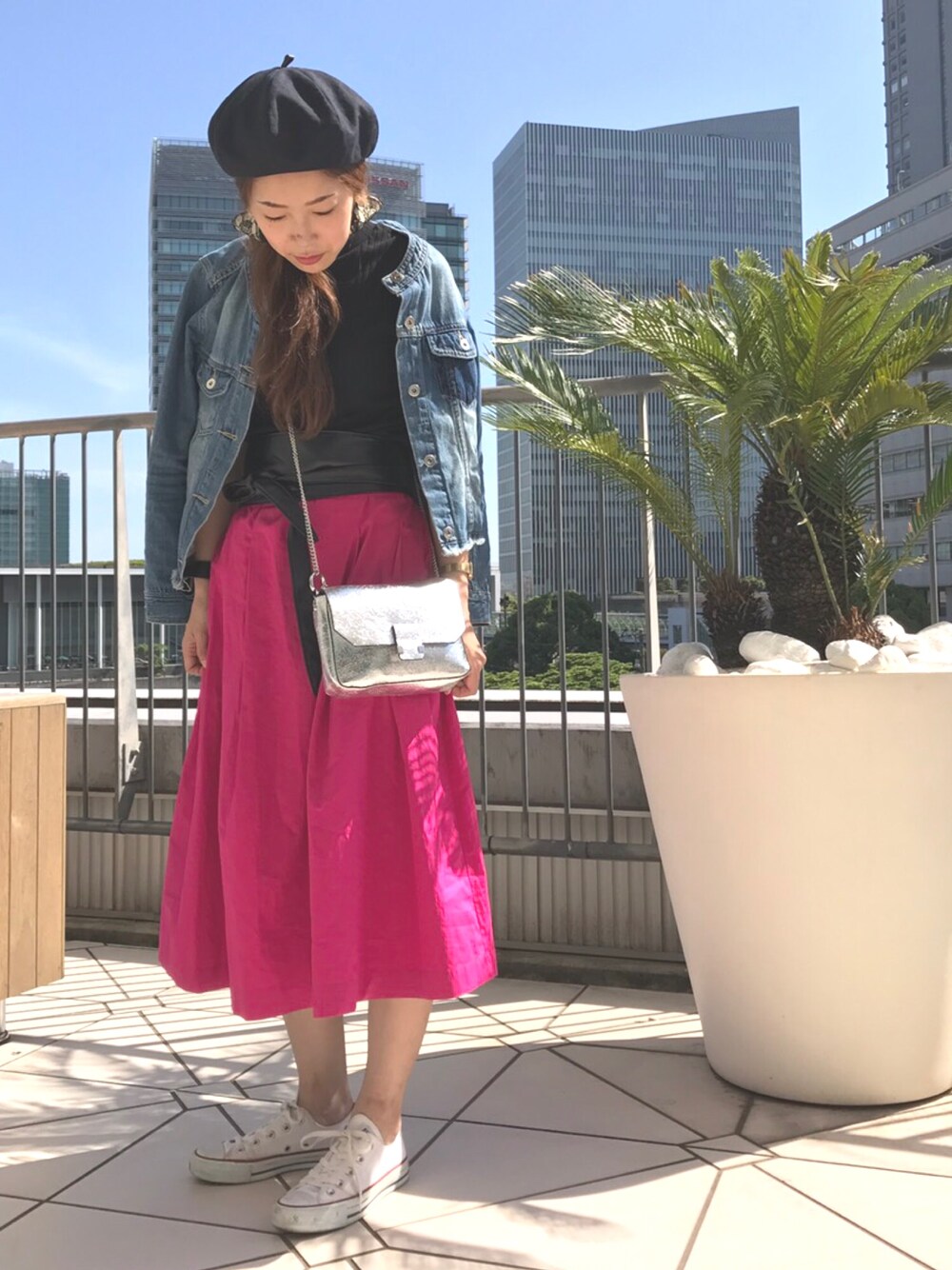 ピンク系のスカート、ブルー系のミリタリージャケット、ホワイト系のスニーカーを着用したレディースの夏コーディネートの1枚目の写真