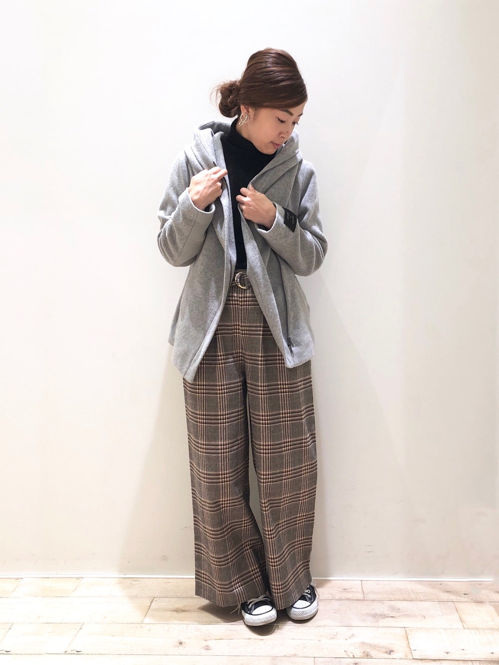 グレー系のピーコート、ブラック系のニット/セーター、ベージュ系のその他パンツを着用したレディースの秋コーディネートの1枚目の写真