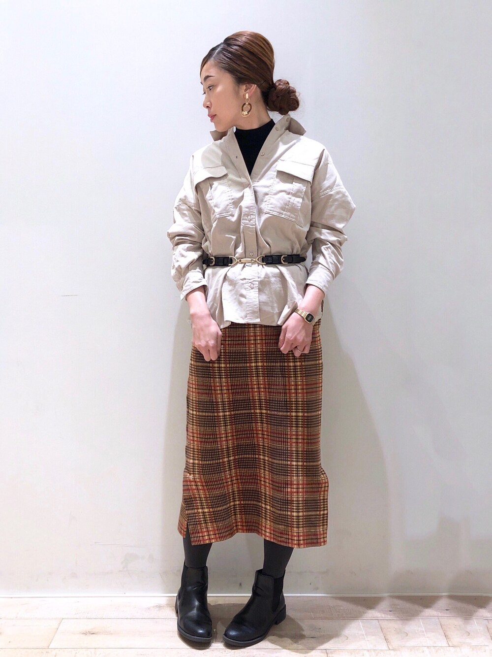 ブラック系のニット/セーター、ホワイト系のシャツ/ブラウス、その他のスカートを着用したレディースの秋コーディネートの1枚目の写真