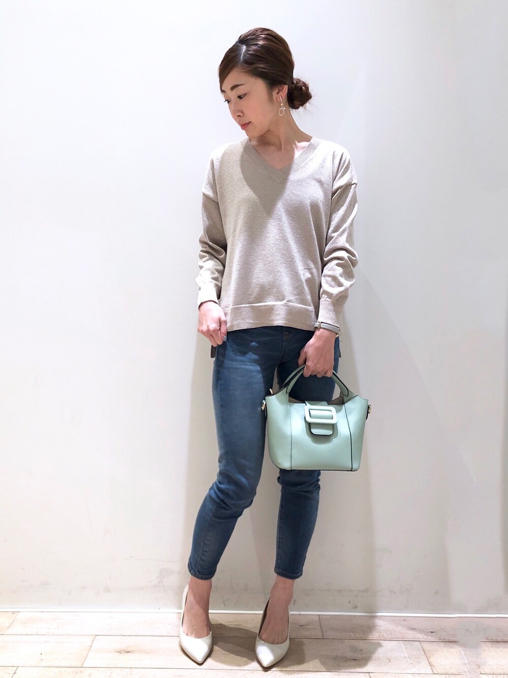 ベージュ系のニット/セーター、ブルー系のその他パンツ、グリーン系のトートバッグを着用したレディースの冬コーディネートの1枚目の写真