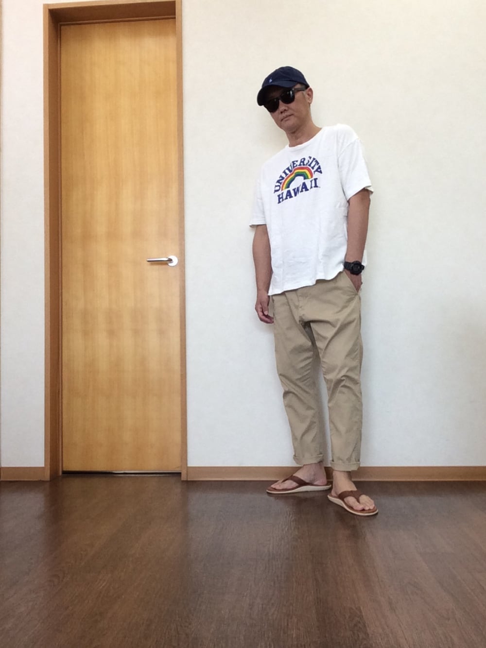 「シンプルコーデ、カジュアル、キャップ、カレッジ、ビーチサンダル、ビーサン、チノパン、夏コーデ」｜「JOURNAL STANDARD relumeのHOLIDAYS COMFORT×relume / HAWAII UNIV 別注ハワイ大学Tシャツ#（Tシャツ/カットソー、ホワイト系）」を使った、シュウさん（メンズ・173cm）の夏コーディネートの1枚目の写真