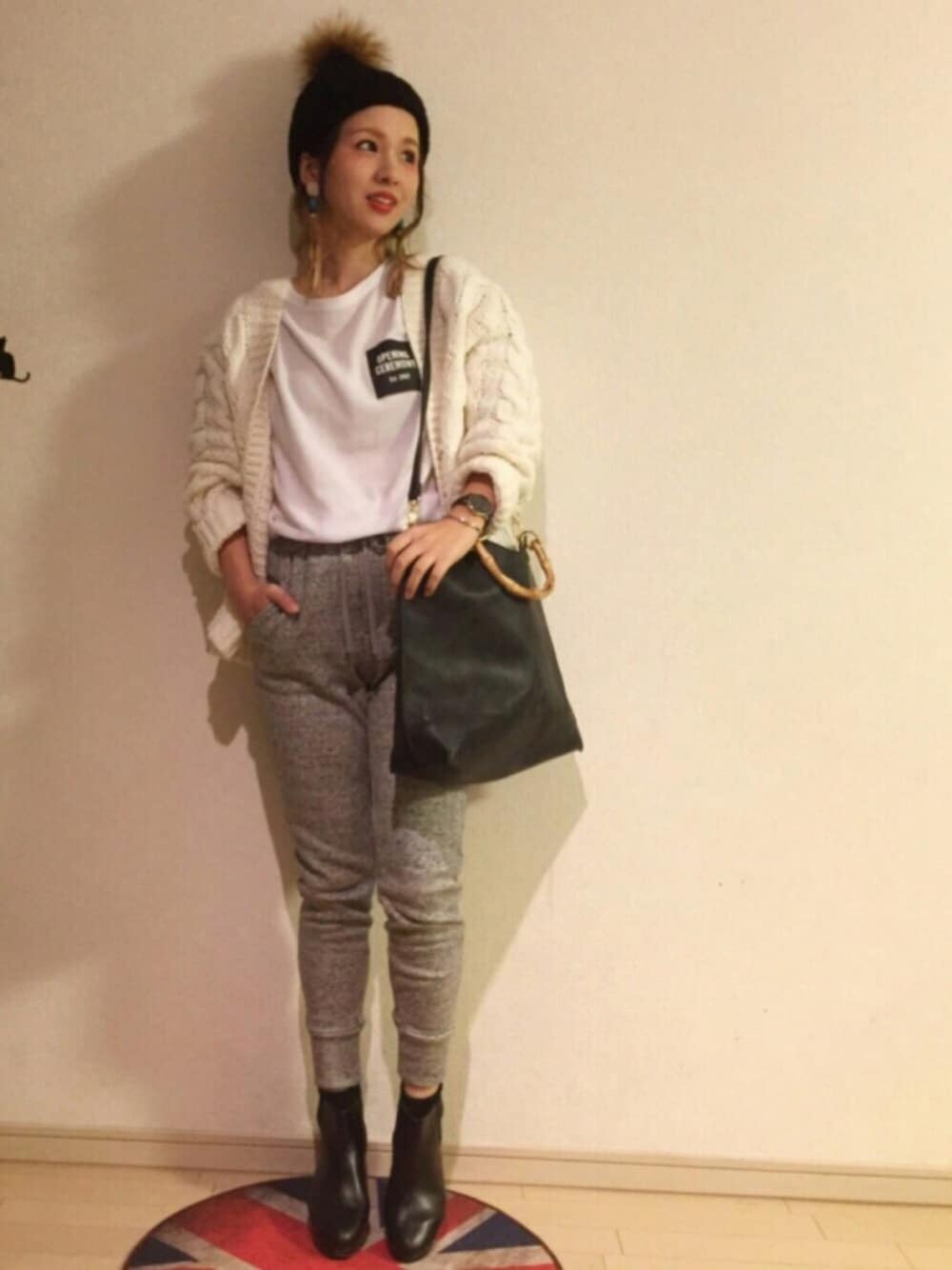 ホワイト系のカーディガン/ボレロ、ホワイト系のトップス、グレー系のパンツを着用したレディースの秋コーディネートの1枚目の写真