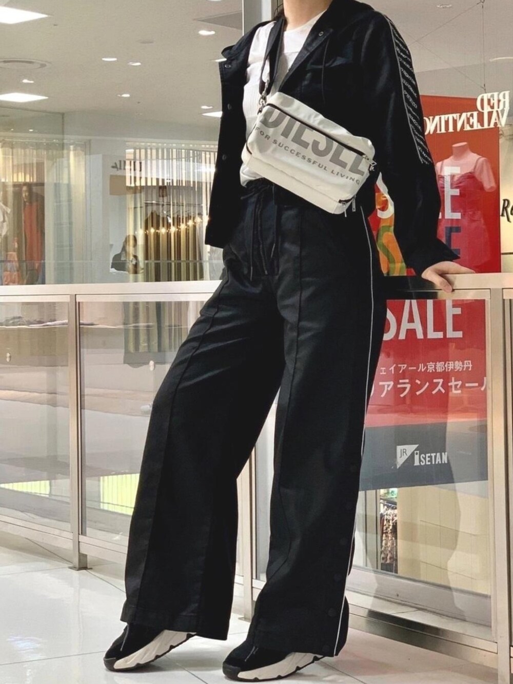 ブラック系のデニムパンツ、ホワイト系のボディバッグ/ウエストポーチ、ホワイト系のTシャツ/カットソーを着用したレディースの夏コーディネートの1枚目の写真