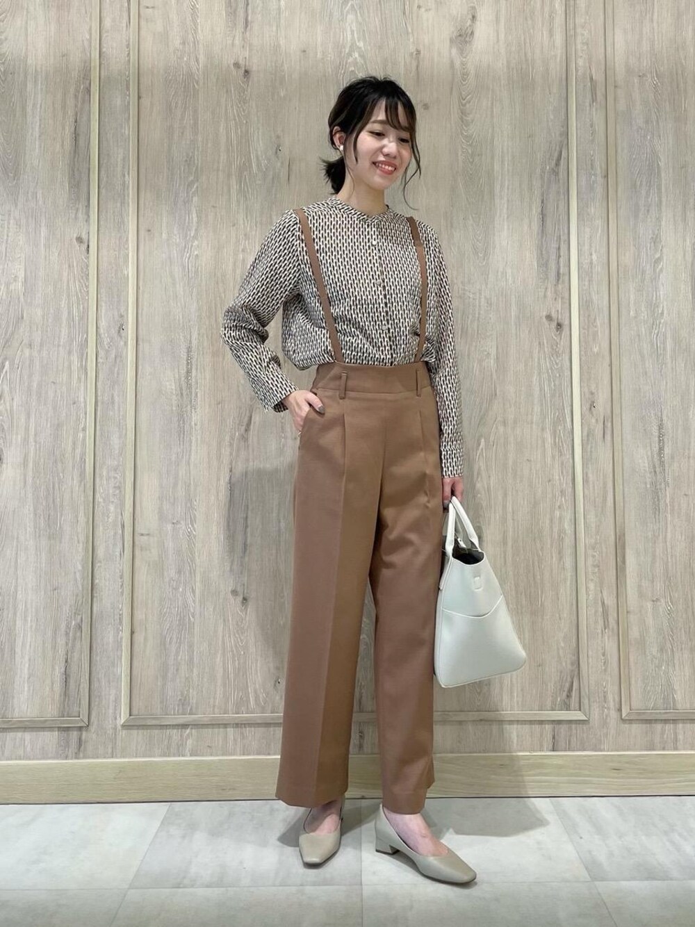 ホワイト系のショルダーバッグ、ベージュ系のパンプス、ブラウン系のその他パンツを着用したレディースの秋コーディネートの1枚目の写真