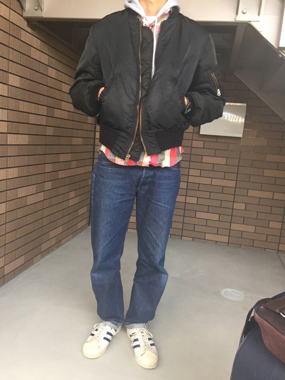 ブラック系のその他アウター、グレー系のパーカー、レッド系のシャツ/ブラウスを着用したメンズの冬コーディネートの1枚目の写真