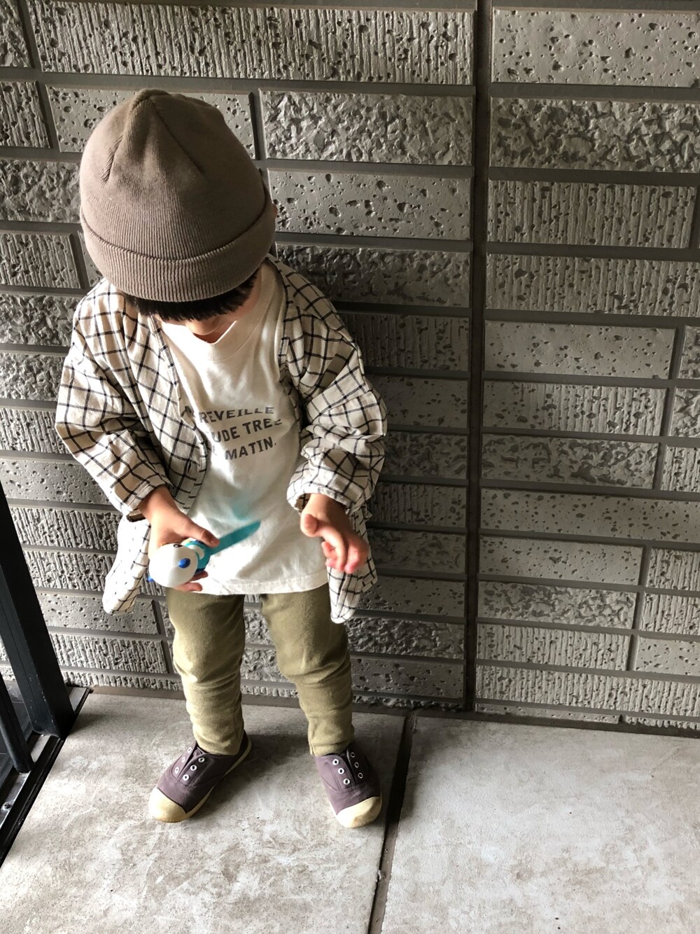 ベージュ系のシャツ/ブラウス、ベージュ系のTシャツ/カットソー、グレー系のスニーカーを着用したキッズの秋コーディネートの1枚目の写真