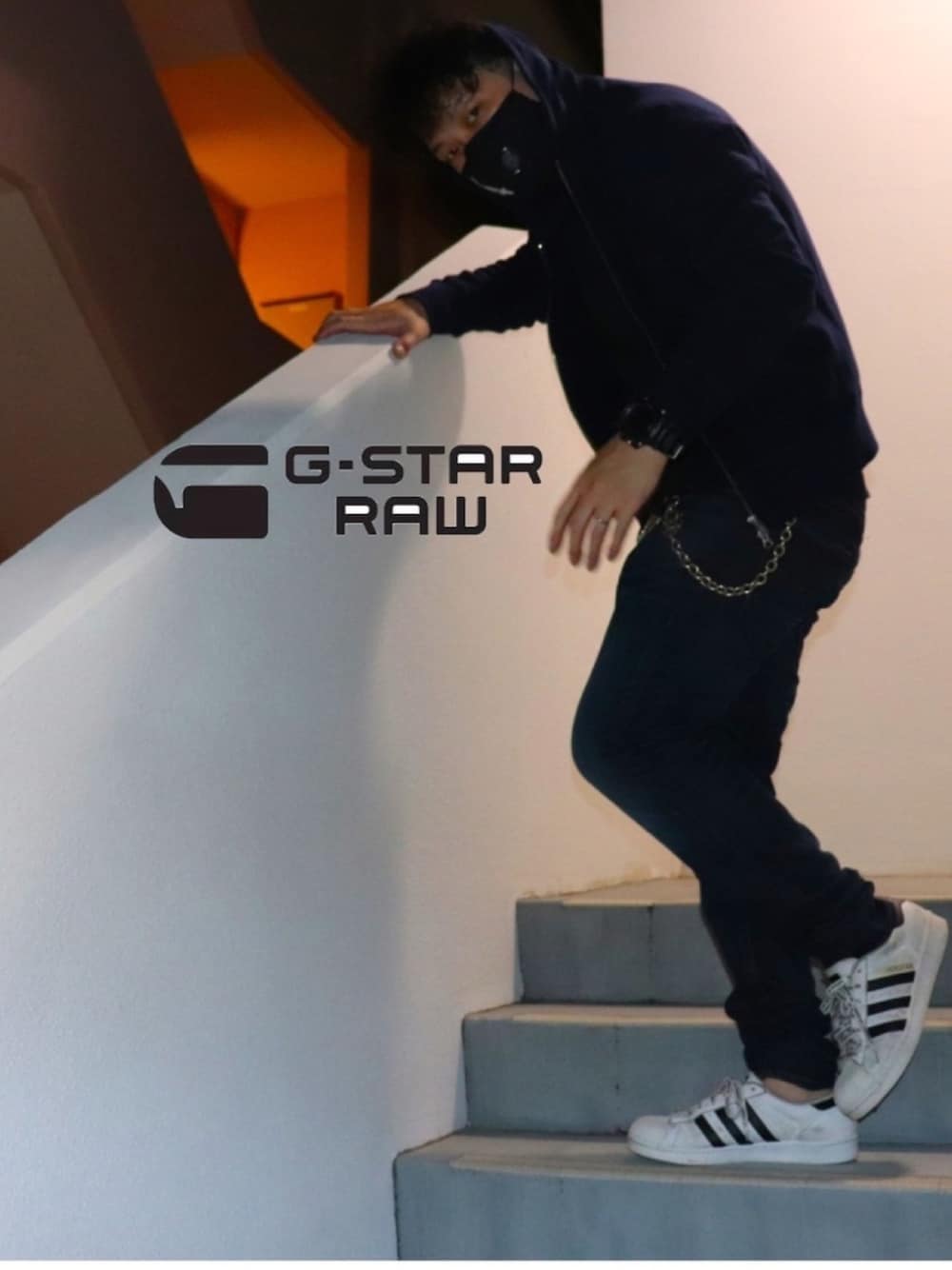 ホワイト系のスニーカー、ブルー系のデニムパンツ、グレー系のパーカーを着用したメンズの夏コーディネートの1枚目の写真