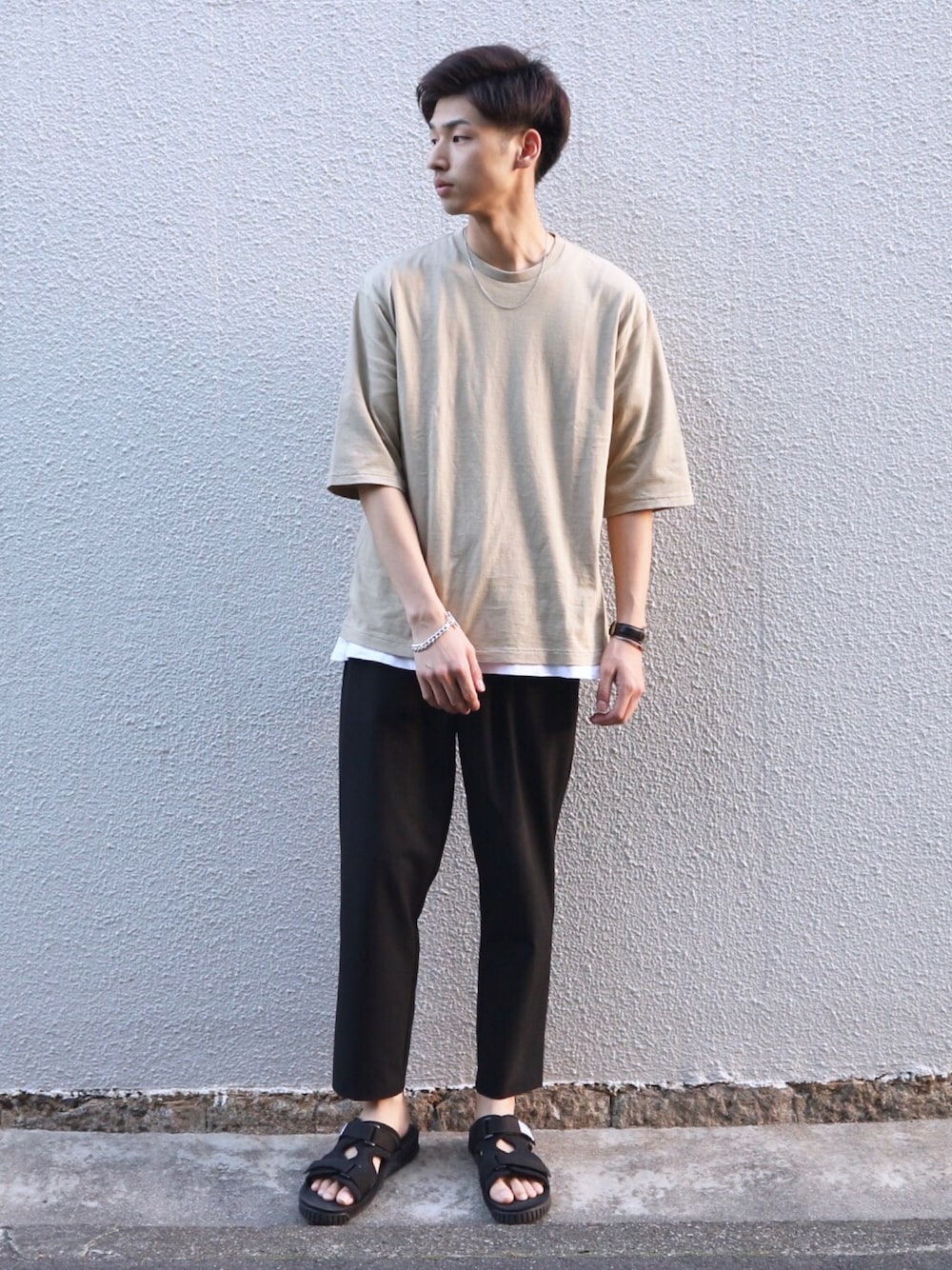 ベージュ系のTシャツ/カットソー、ブラック系のその他パンツ、ブラック系のサンダルを着用したメンズの春コーディネートの1枚目の写真