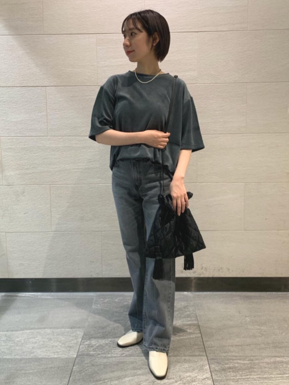 グリーン系のTシャツ/カットソー、ブラック系のショルダーバッグ、ブラック系のデニムパンツを着用したレディースの夏コーディネートの1枚目の写真