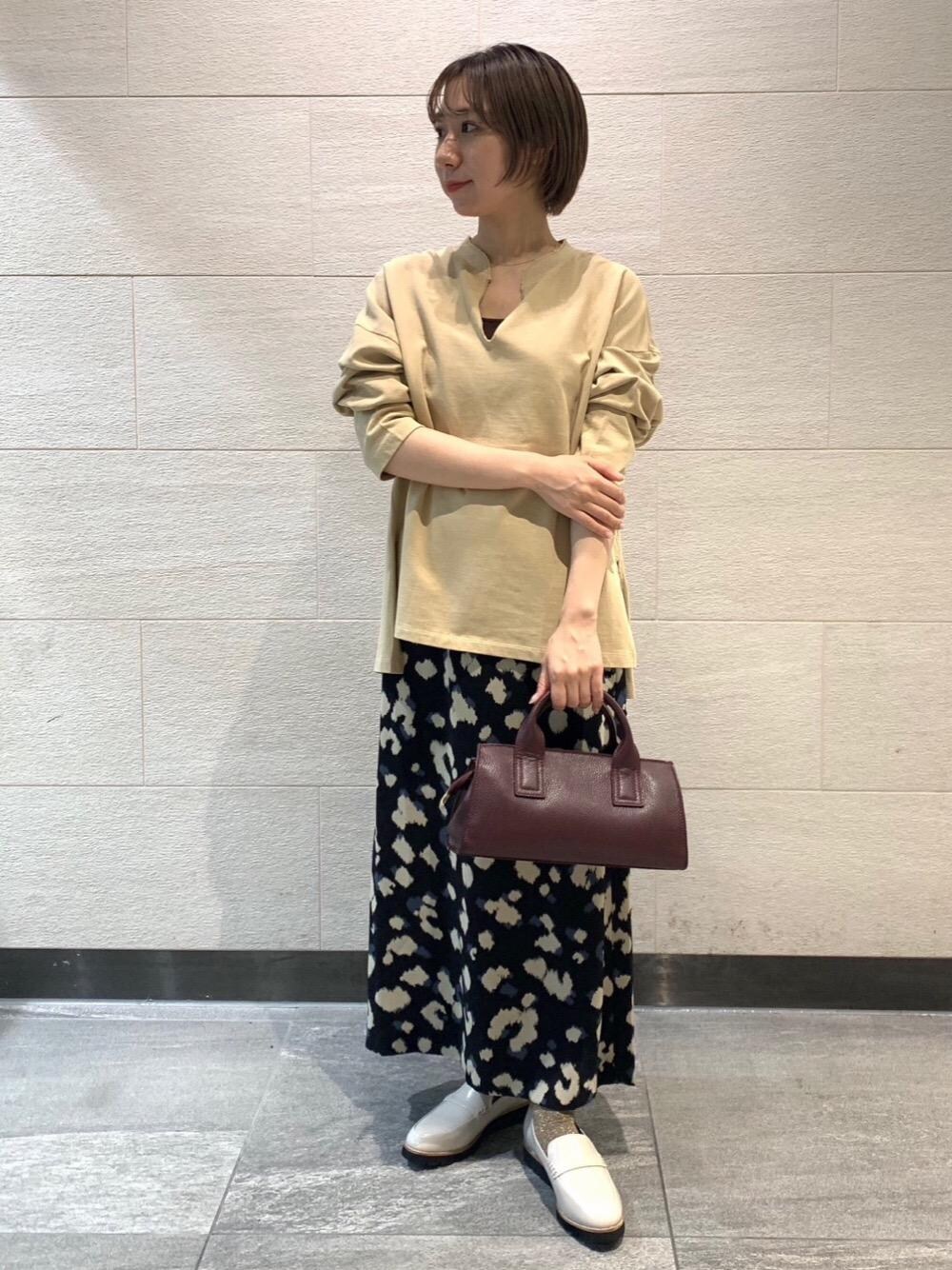 ベージュ系のローファー、ブラック系のスカート、イエロー系のスウェットを着用したレディースの秋コーディネートの1枚目の写真