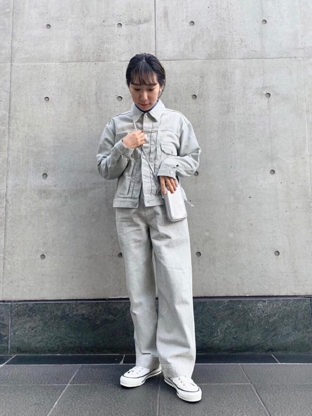 ホワイト系のスニーカー、ブルー系のデニムパンツ、ブルー系のデニムジャケットを着用したレディースの冬コーディネートの1枚目の写真