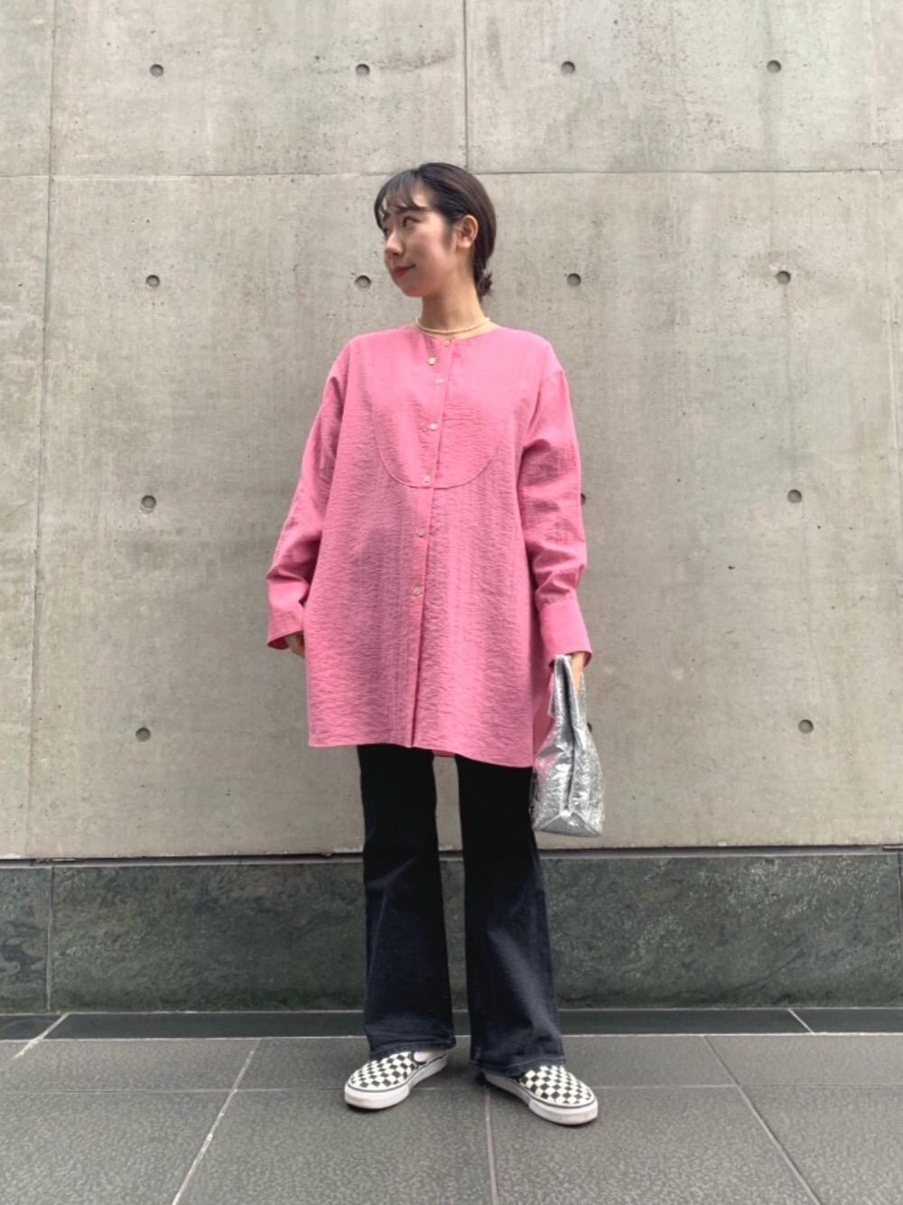 ブラック系のデニムパンツ、ピンク系のシャツ/ブラウス、シルバー系のトートバッグを着用したレディースの冬コーディネートの1枚目の写真