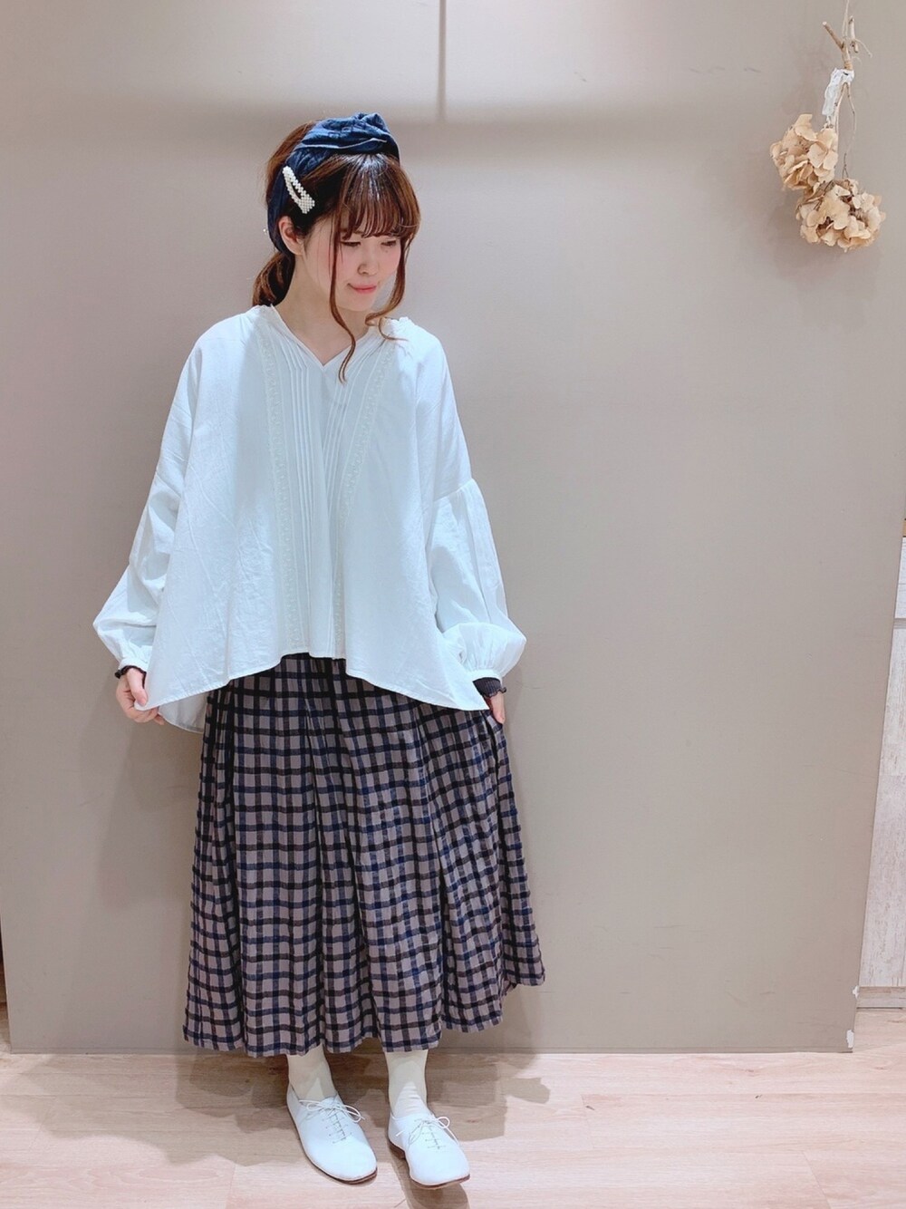 ホワイト系のシャツ/ブラウス、グレー系のスカート、ホワイト系のその他シューズを着用したレディースの冬コーディネートの1枚目の写真