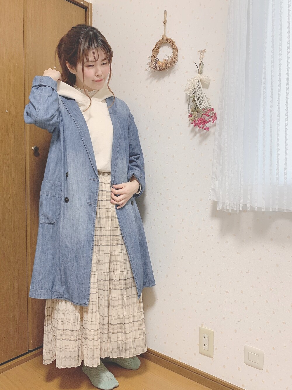 ブルー系のデニムジャケット、ベージュ系のスカート、ベージュ系のパーカーを着用したレディースの春コーディネートの1枚目の写真