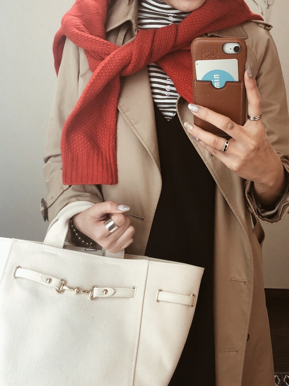 ベージュ系のトレンチコート、レッド系のニット/セーター、ホワイト系のトートバッグを着用したレディースの冬コーディネートの1枚目の写真