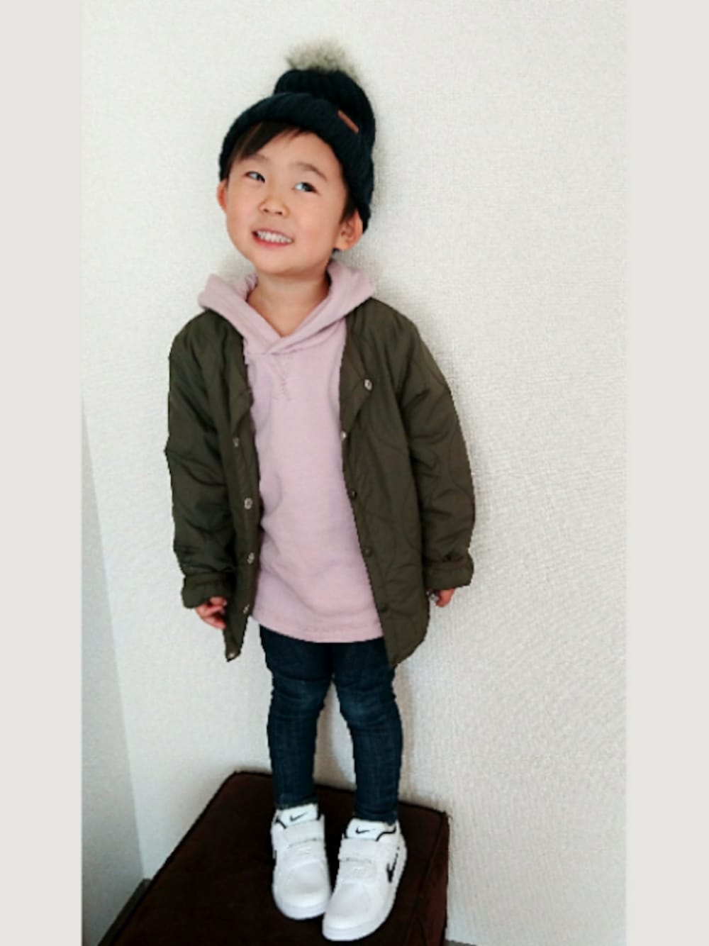 ブルー系のデニムパンツ、ピンク系のスウェット、ホワイト系のスニーカーを着用したキッズの冬コーディネートの1枚目の写真