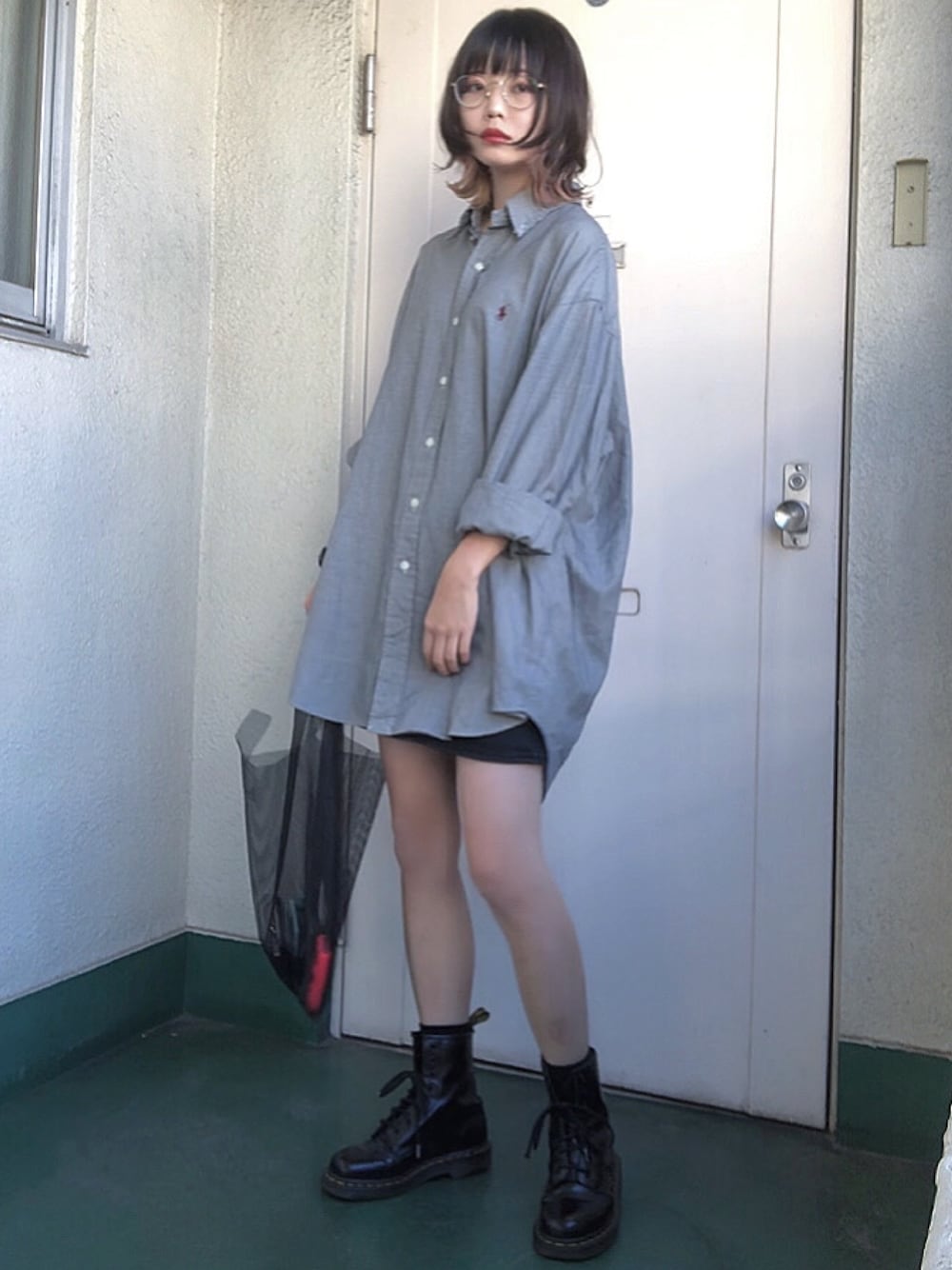 ブラック系のデニムスカート、ブラック系のブーツ、ブラック系のバッグを着用したレディースの秋コーディネートの1枚目の写真