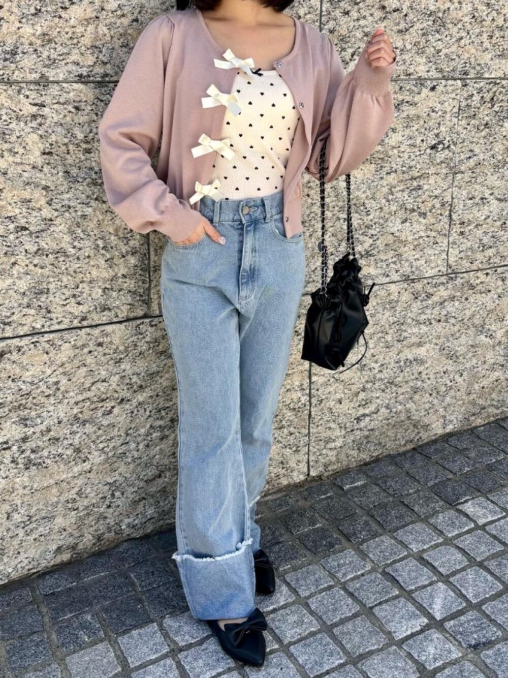 ブルー系のデニムパンツ、ブラック系のパンプス、ホワイト系のキャミソールを着用したレディースの春コーディネートの1枚目の写真