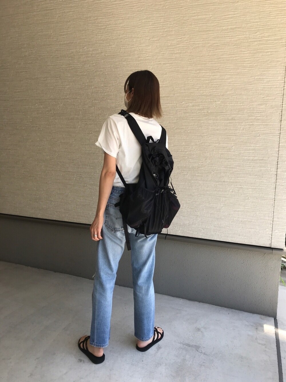 ホワイト系のTシャツ/カットソー、ブルー系のデニムパンツ、ブラック系のサンダルを着用したレディースの夏コーディネートの1枚目の写真