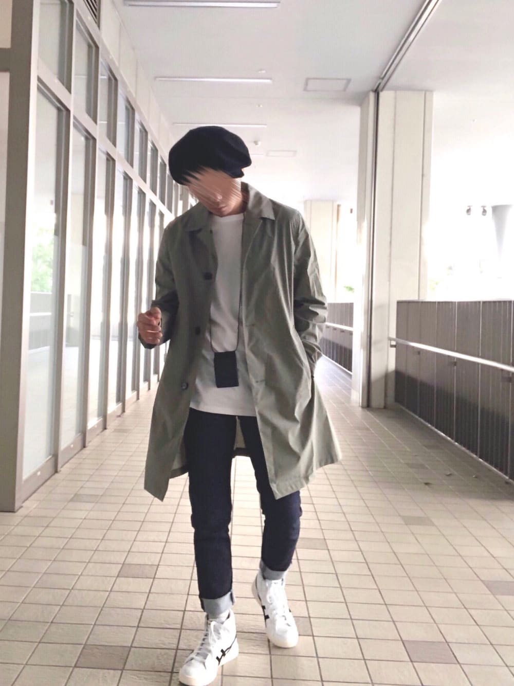 グリーン系のステンカラーコート、ホワイト系のTシャツ/カットソー、ブルー系のデニムパンツを着用したメンズの秋コーディネートの1枚目の写真