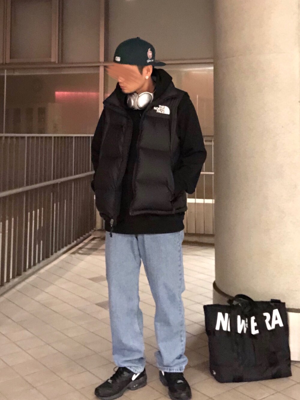 ブラック系のスニーカー、ブルー系のデニムパンツ、ブラック系のパーカーを着用したメンズの秋コーディネートの1枚目の写真