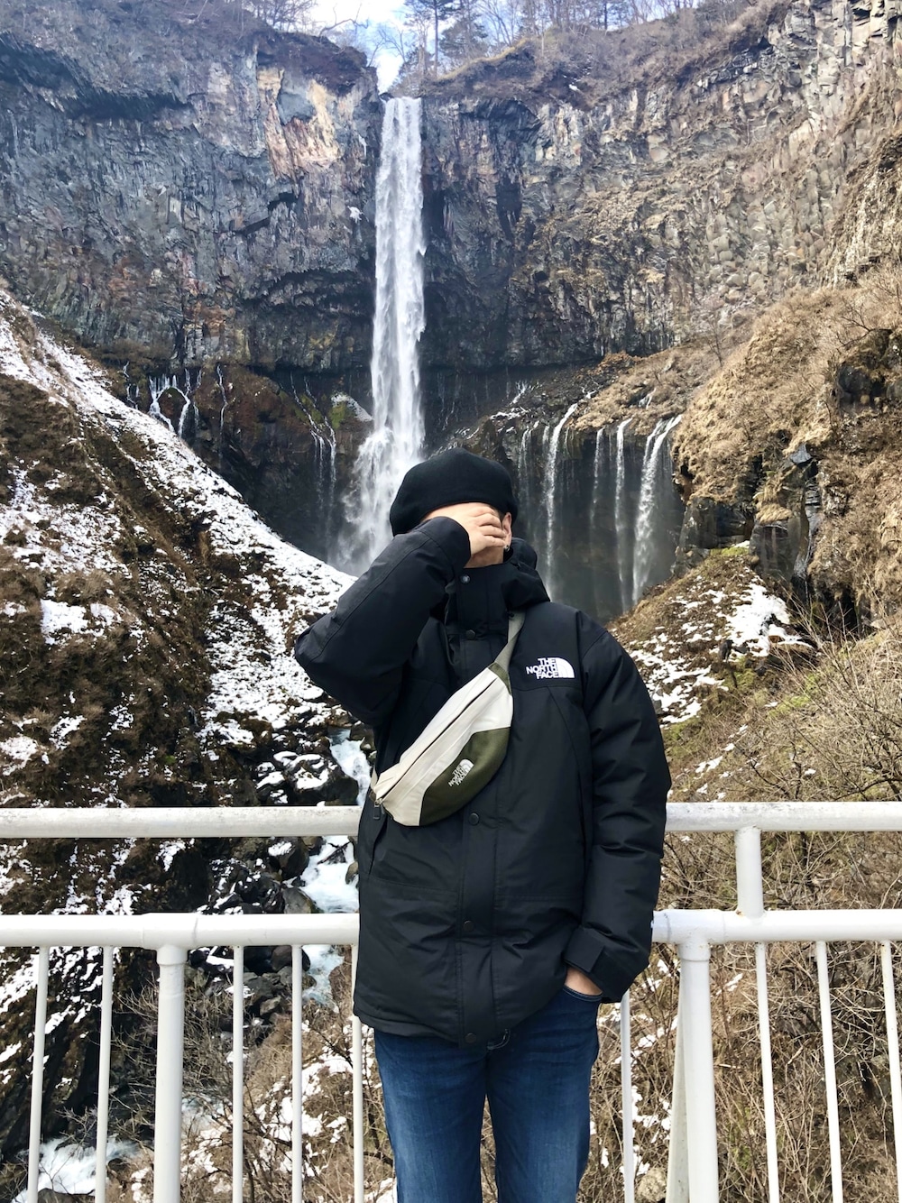 ブラック系のダウンジャケット/コート、ホワイト系のボディバッグ/ウエストポーチを着用したメンズの冬コーディネートの1枚目の写真