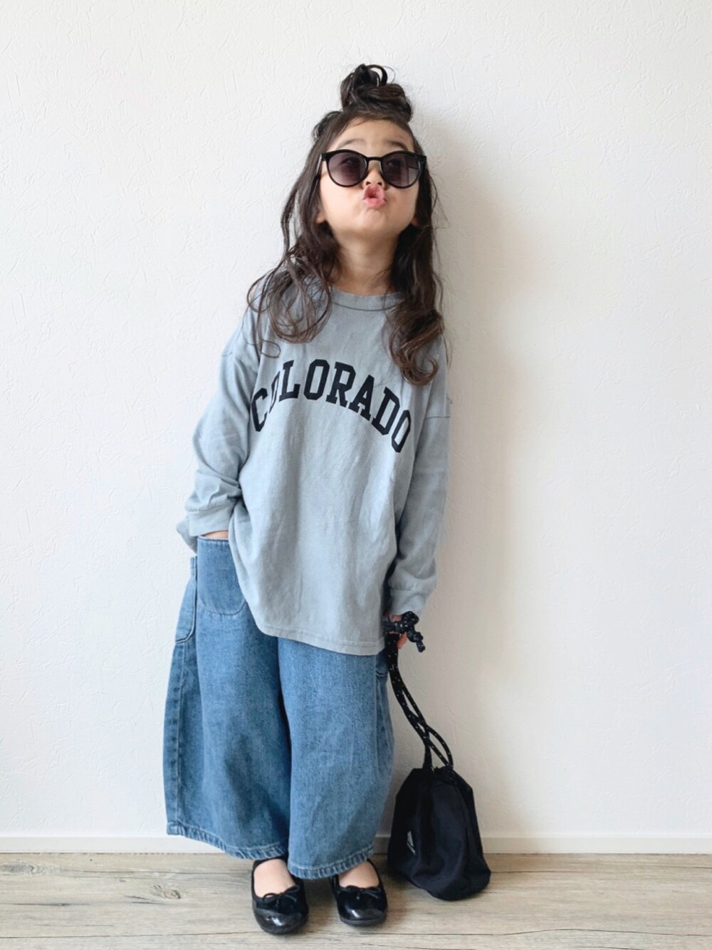 ブルー系のTシャツ/カットソー、ブルー系のデニムパンツ、ブラック系のハンドバッグを着用したキッズの春コーディネートの1枚目の写真
