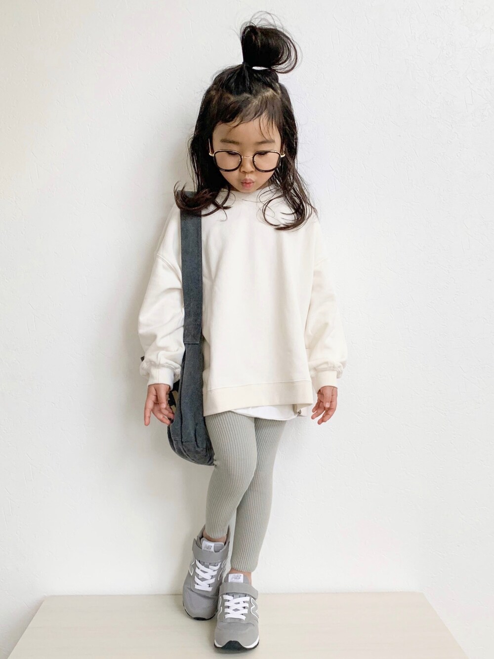 ホワイト系のスウェット、グレー系のスニーカー、ブラック系のショルダーバッグを着用したキッズの冬コーディネートの1枚目の写真