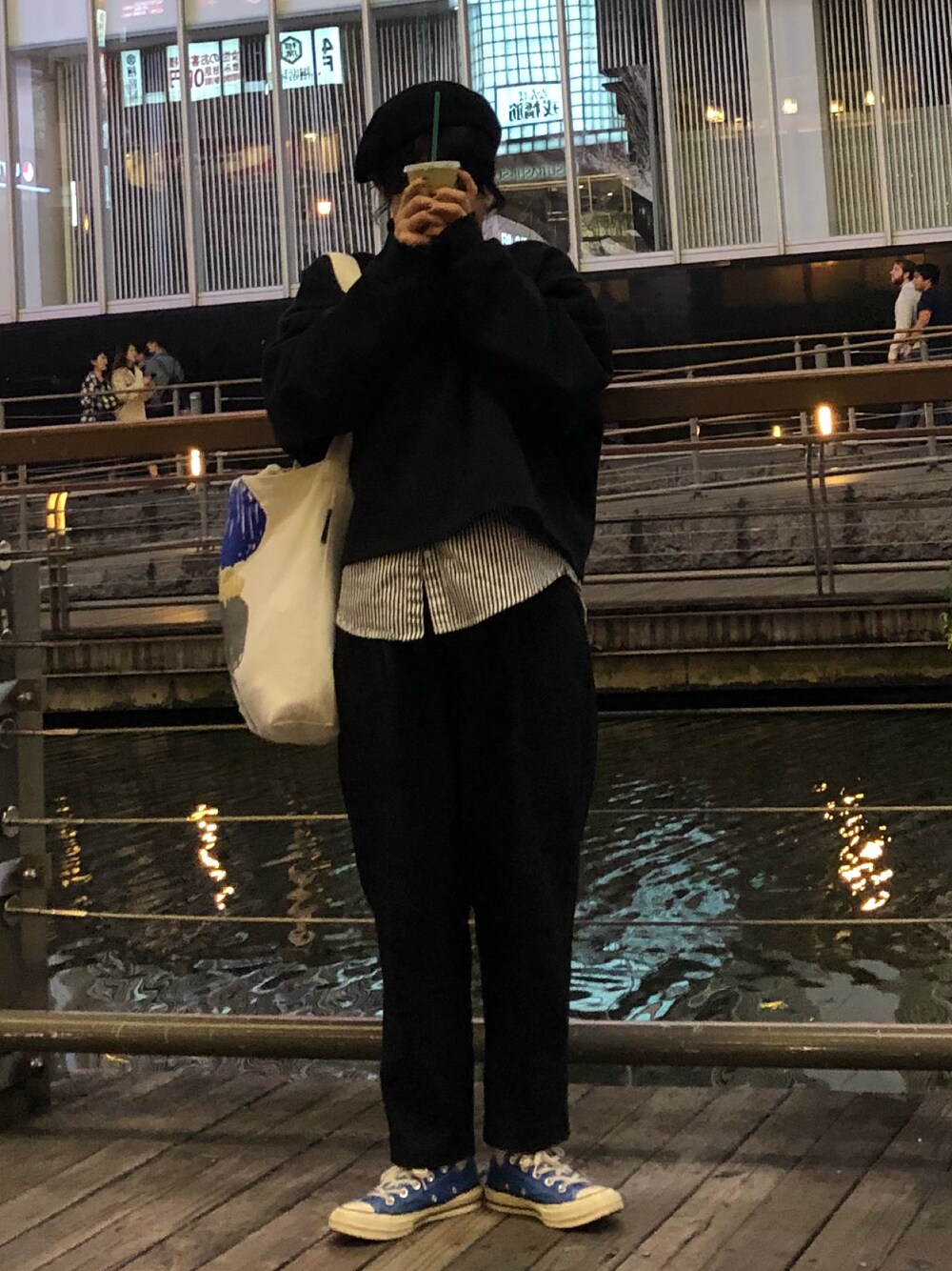 ブラック系のスウェット、ブラック系のスラックス、ブルー系のスニーカーを着用したレディースの冬コーディネートの1枚目の写真