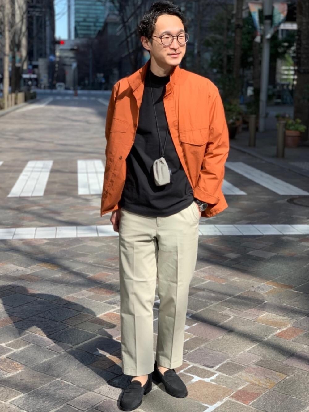 ブラック系のローファー、ブラック系のTシャツ/カットソー、ベージュ系のチノパンツを着用したメンズの冬コーディネートの1枚目の写真